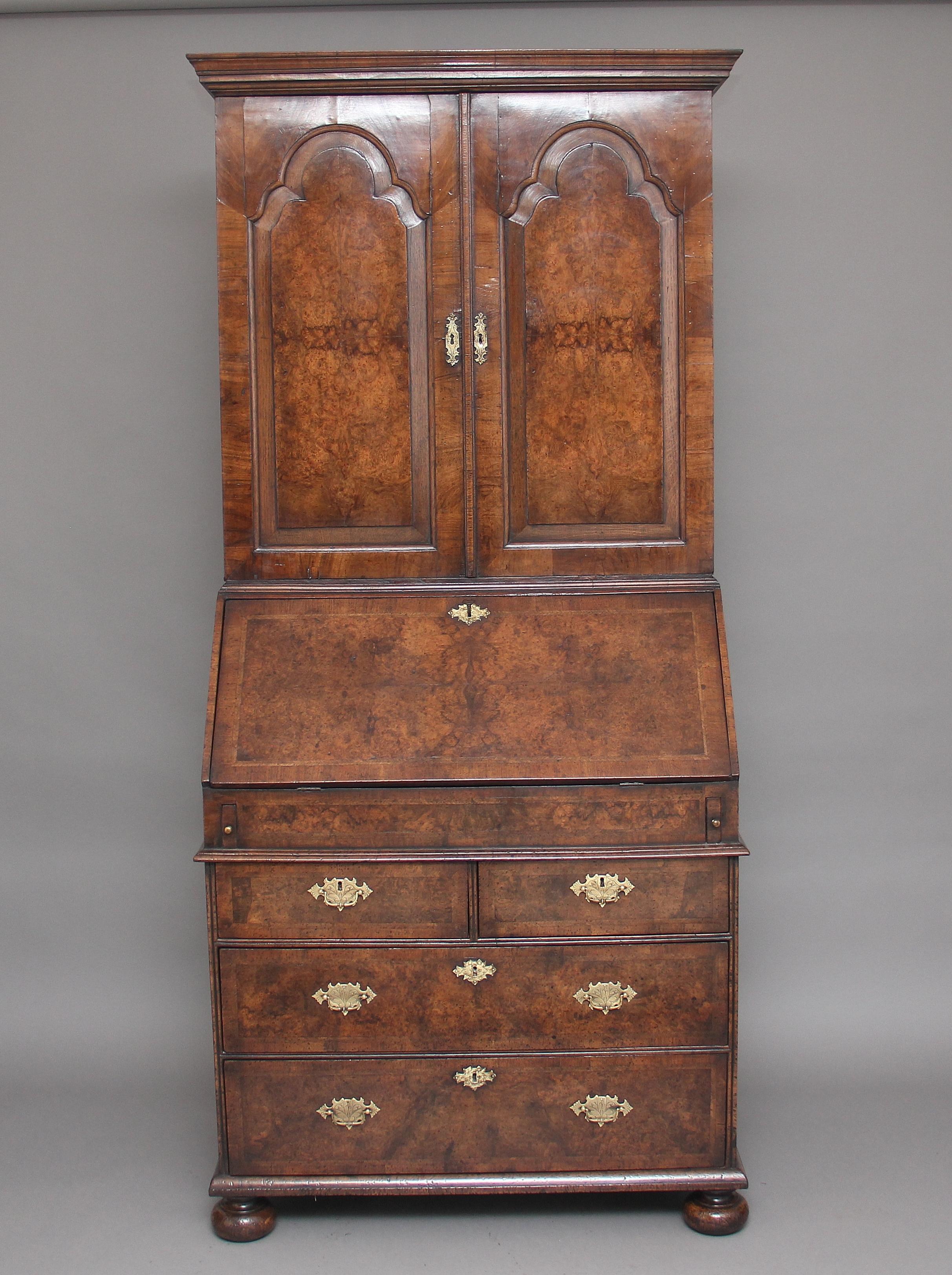 A lovely quality burr walnut bureau bookcase having an 18th century carcass and re-venered in the early 20th century, the moulded cornice above two doors with fielded arched panels opening to reveal various oak lined compartments and drawers, the
