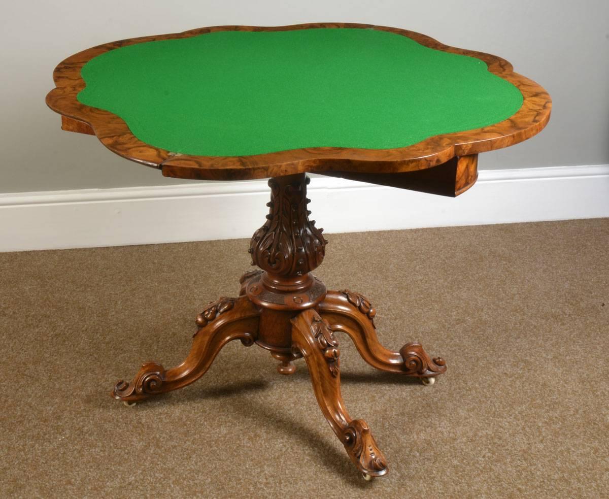 Victorian walnut serpentine front card table, the folding and swivel burr walnut top opening to reveal a baize lined interior with tooled border, on a turned and carved stem and conforming scroll legs to ceramic castors.
Dimensions:
Height 29.5