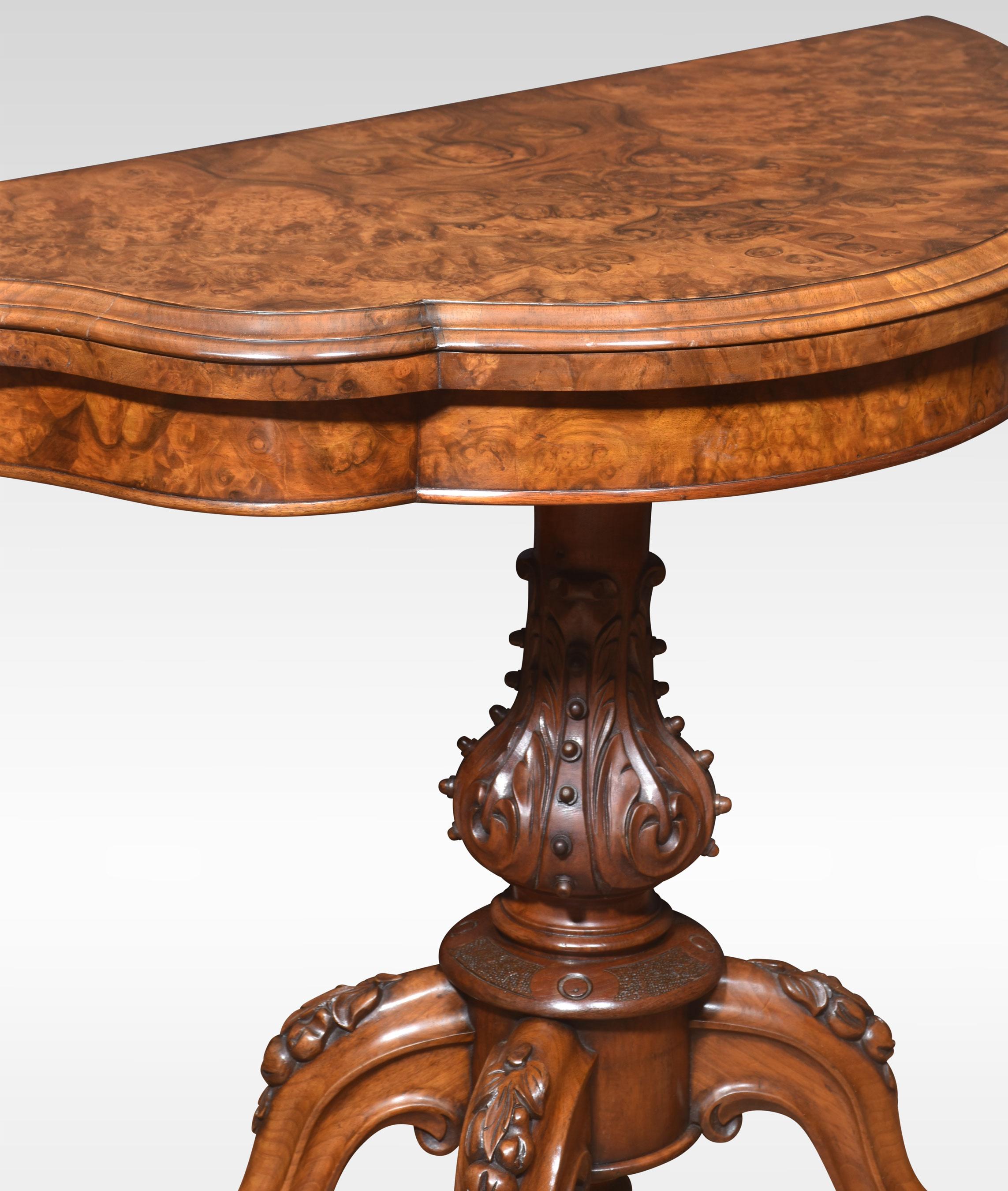 Walnut serpentine front card table. The folding and swivel burr walnut top opening to reveal an inset baize-lined interior with tooled border. Raised up on a turned and carved stem and conforming scroll legs to the original ceramic