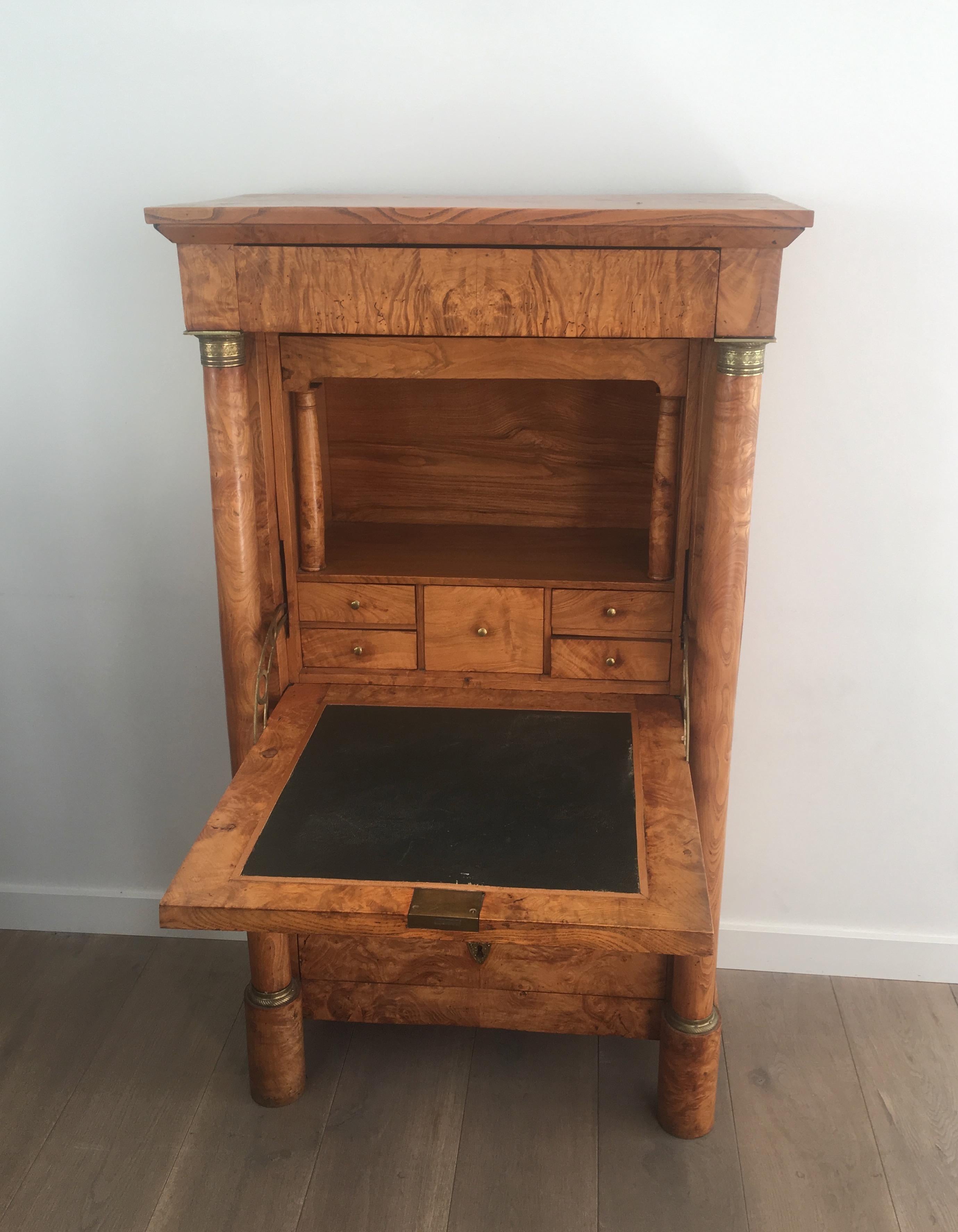 This beautiful Empire clapper secretaire is made of burr walnut. It has very elegant detached columns with Fine chiseled bronze elements on top and bottom of each column. Inside of the secretaire there is leather desk and several drawers including a