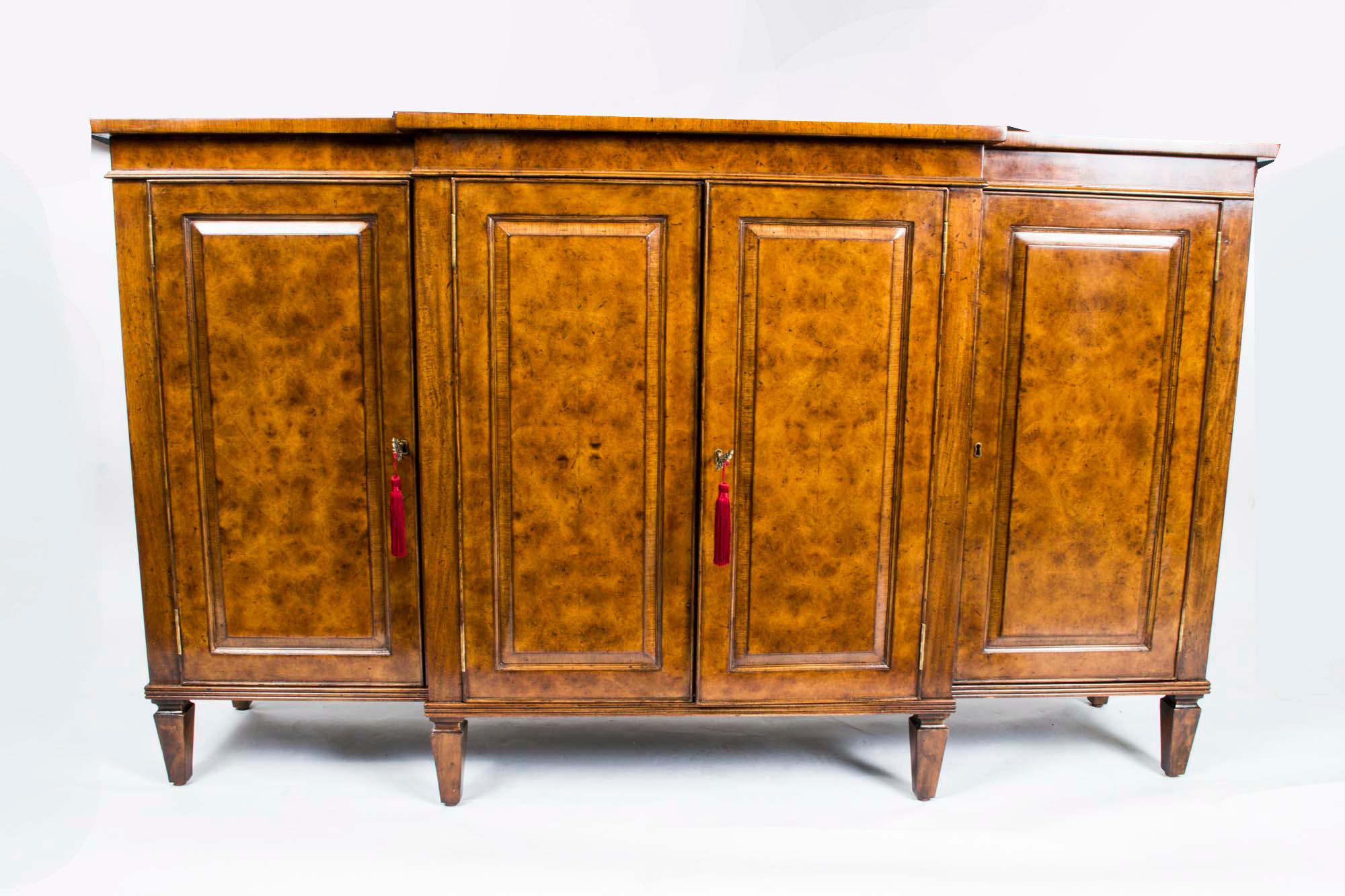 This is a beautiful breakfront burr walnut sideboard with room for all your plates, china, glassware and cutlery, dating from the last quarter of the 20th century.

 It has four doors and that open to reveal a central drawer, for cutlery, etc, and