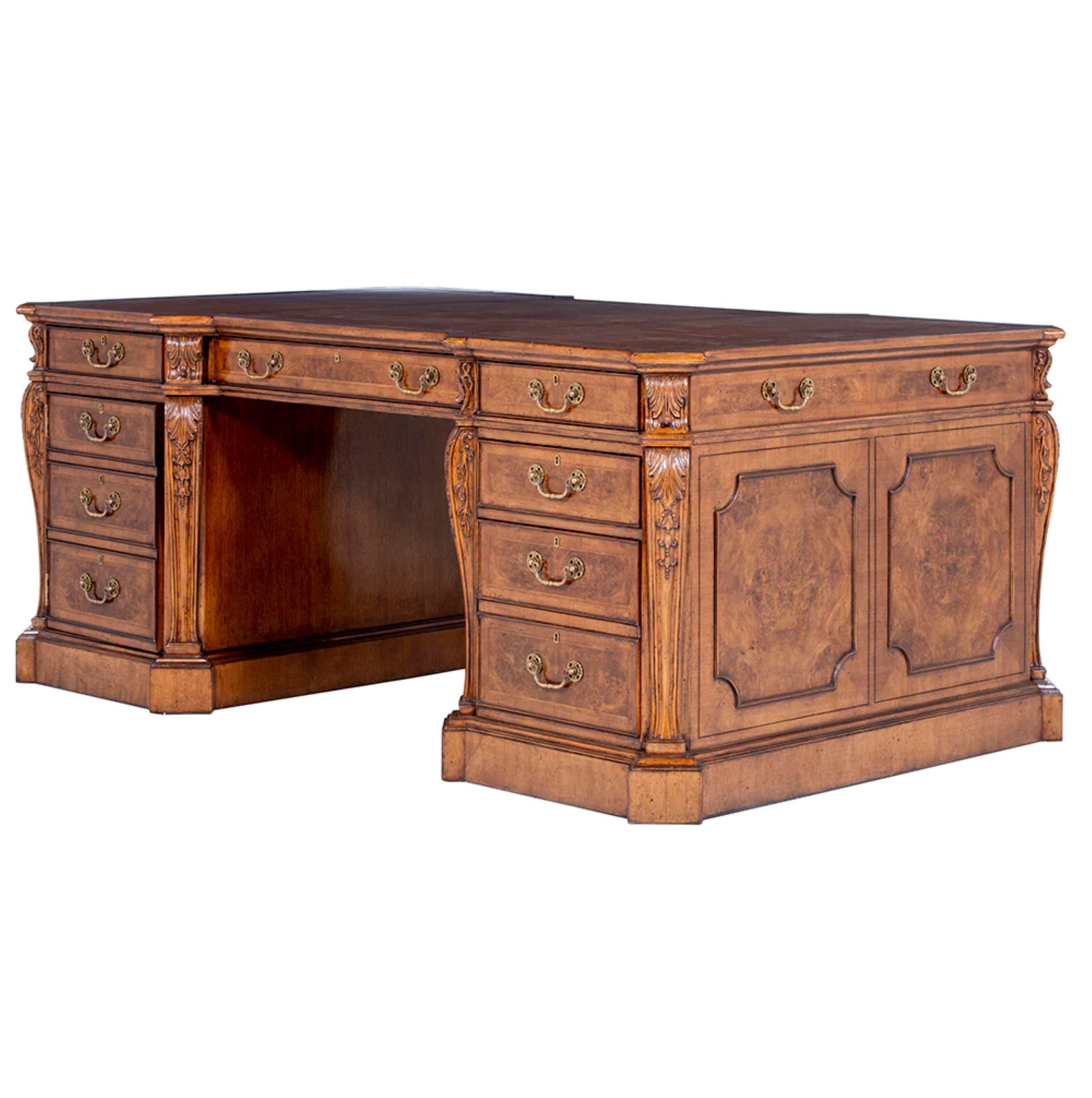 Ce magnifique bureau à piédestal en ronce de noyer est doté d'une surface d'écriture en cuir insérée en trois sections et travaillée à la main. Les tiroirs gradués et façonnés sont tous revêtus de chêne, assemblés à queue d'aronde et munis de