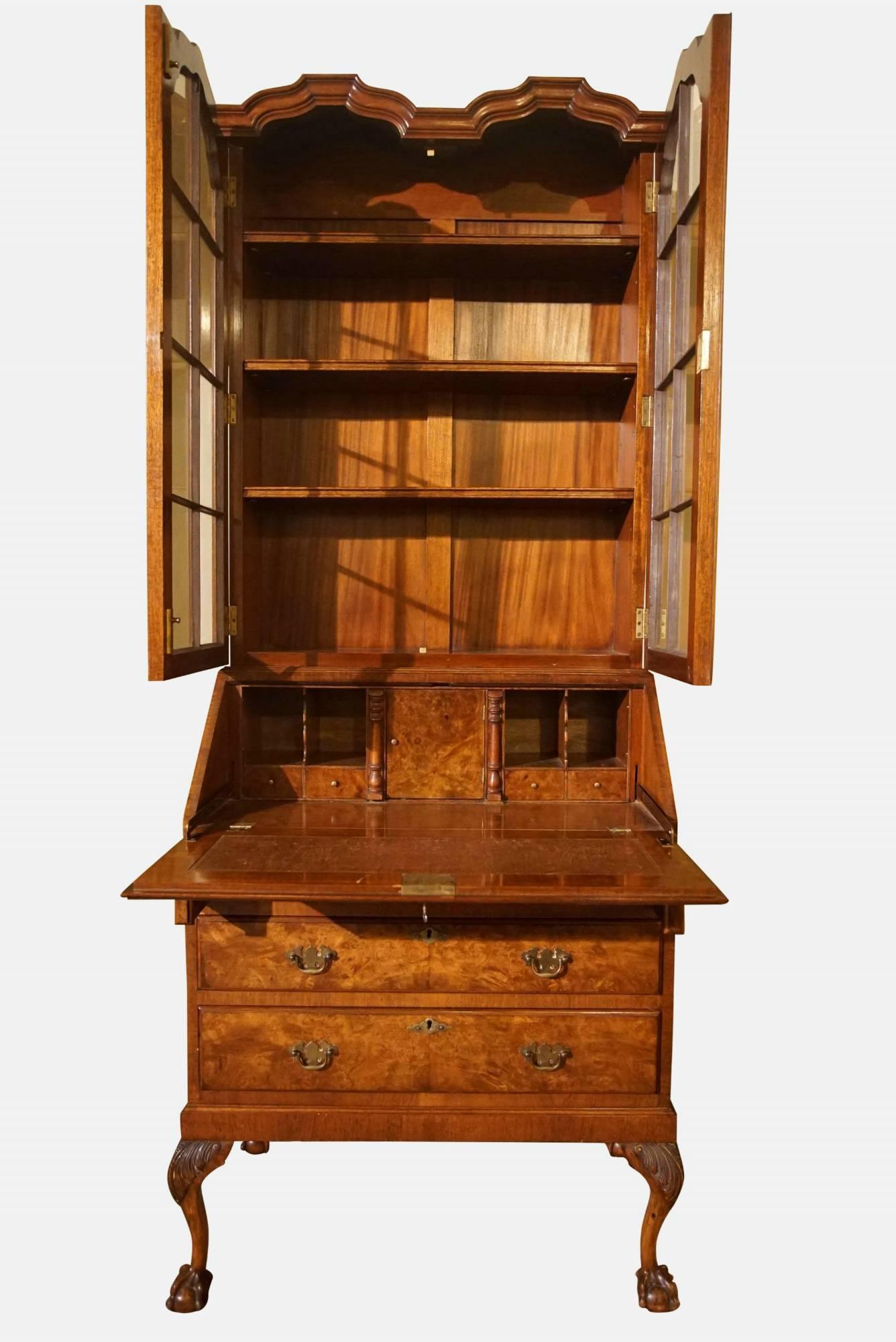 A burr walnut queen anne style double-dome bureau bookcase with full interior standing on cabriole legs and ball and claw feet.

circa 1930.