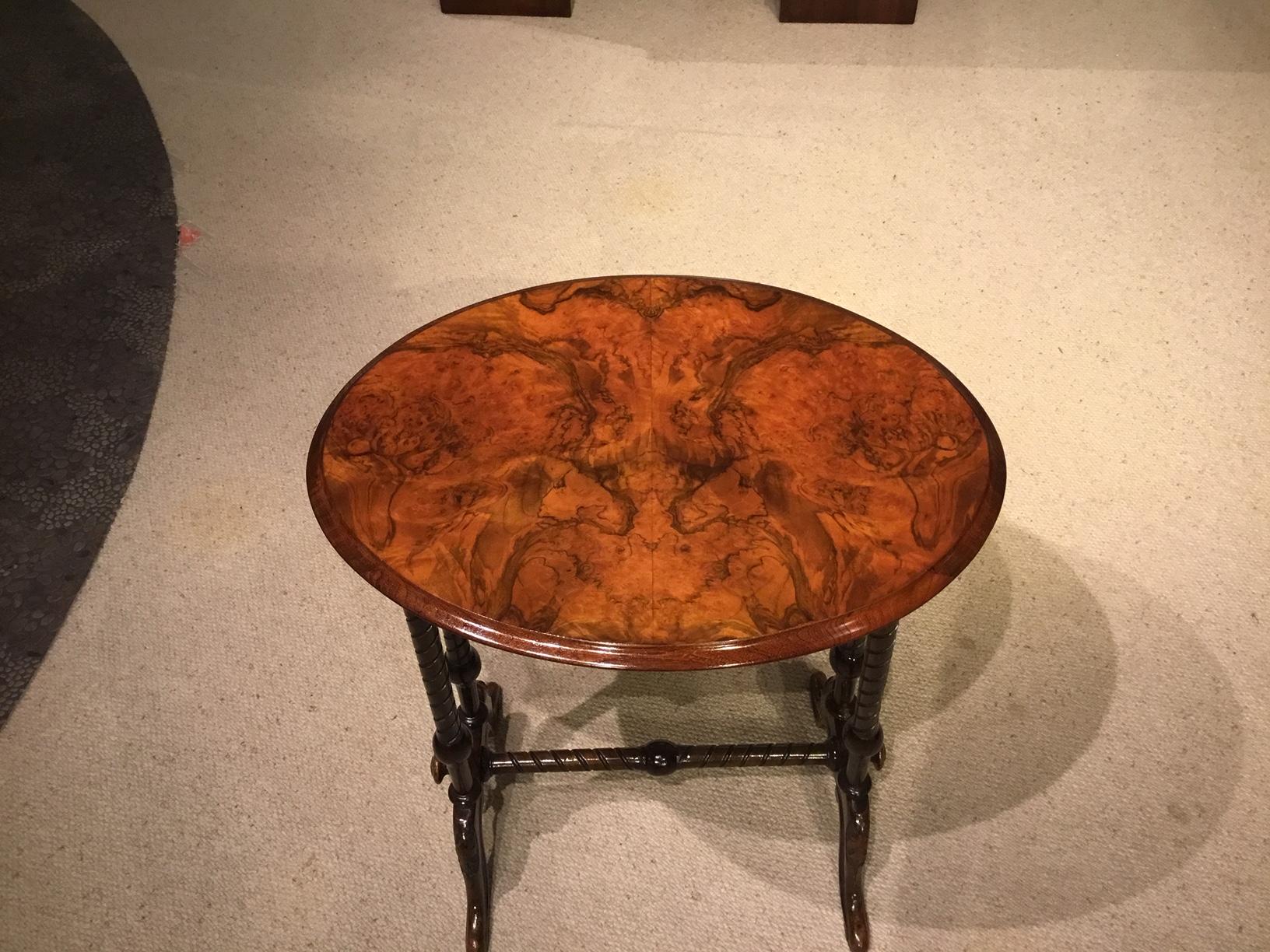 A burr walnut Victorian Period oval occasional table. Having an oval top veneered in beautifully figured burr walnut supported on four turned twist column supports and carved cabriole feet united by a turned stretcher, English, circa