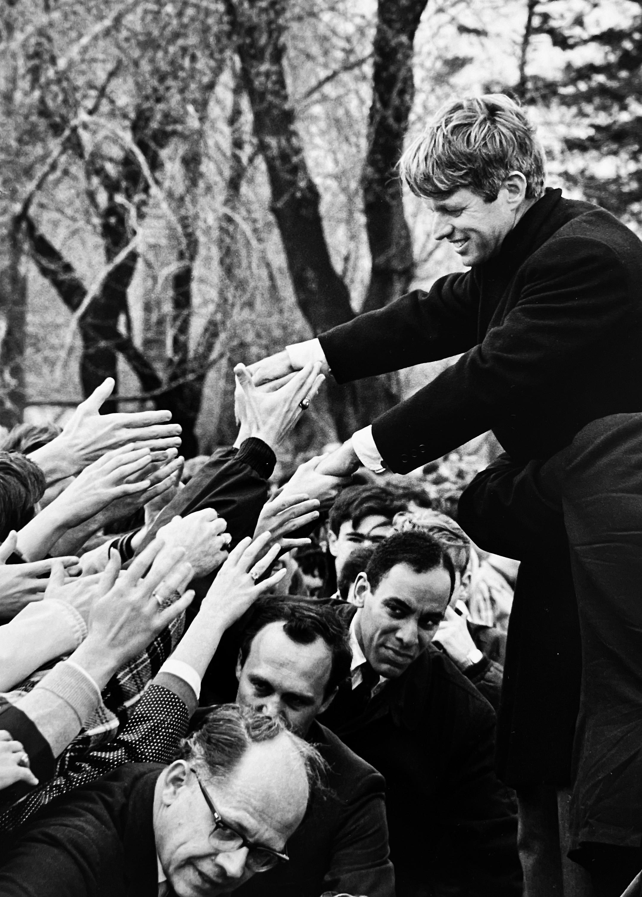 Burt Glinns Schwarz-Weiß-Fotografie von Robert Kennedy (RFK) dokumentiert einen euphorischen Moment aus dem Leben von Robert Fitzgerald Kennedy (RFK) auf dem Campaigner Trail im Jahr 1968. RFK grüßt seine Anhänger bei der Parade in Philadelphia,