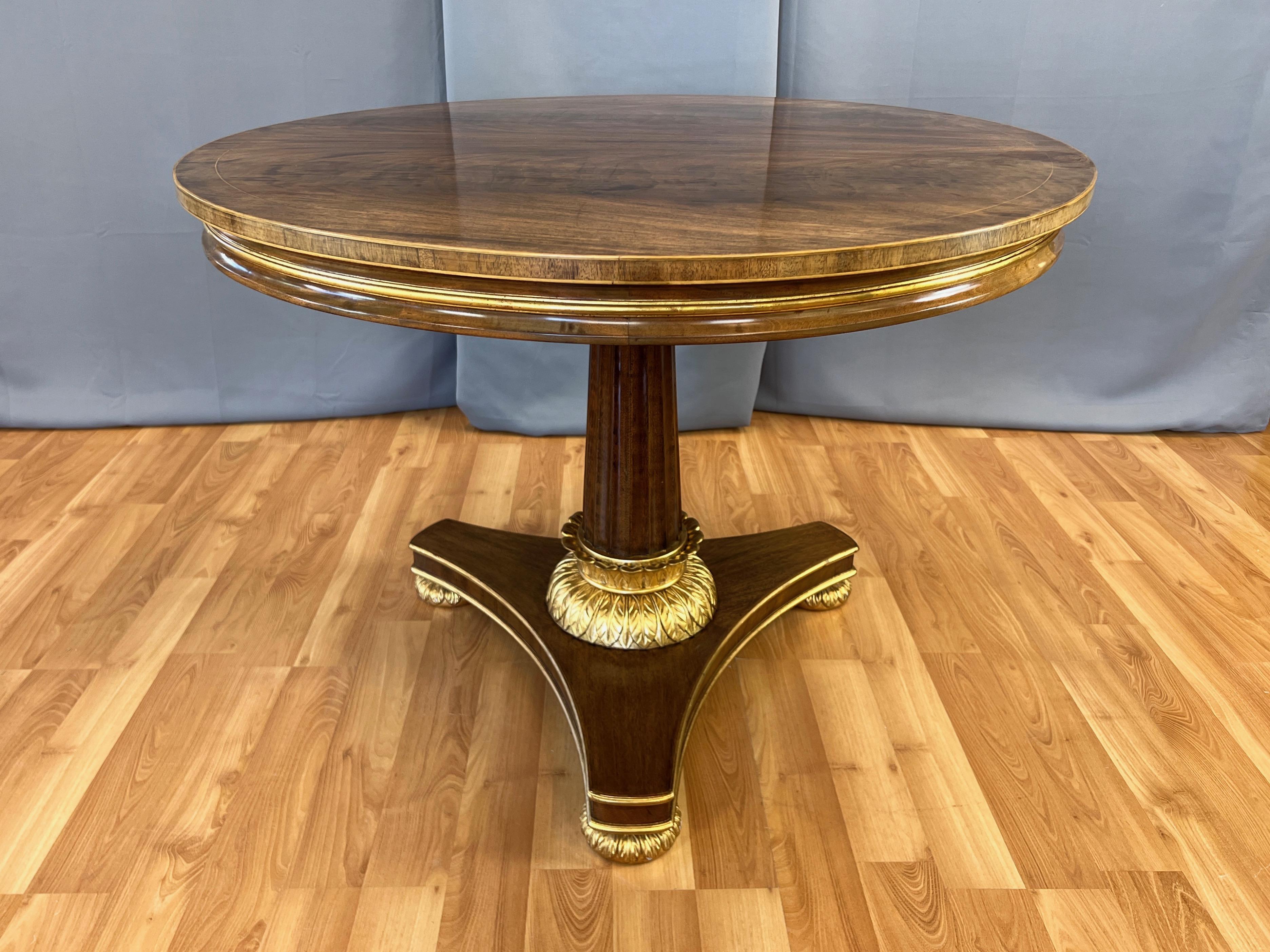 An exquisite and uncommon 1990s Burton-Ching Ltd. Biedermeier-style walnut round pedestal dining table with gorgeous and gleaming giltwood accents.

Top with bookmatched walnut veneer features softly flowing figuring, with a fine gilt line circle