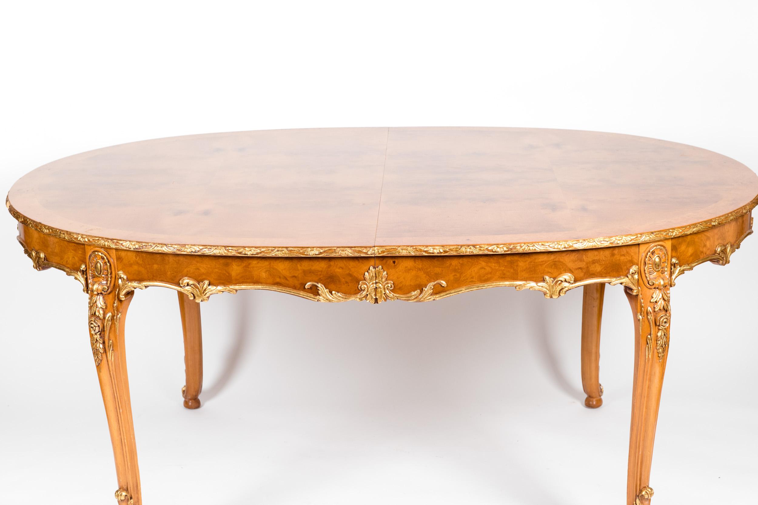Burlwood dining room table with gilt design details. The dining table is in excellent vintage condition . Minor wear consistent with age/ use . The table comes with two extra leaves extension. The table without the extension measures 66 inches long