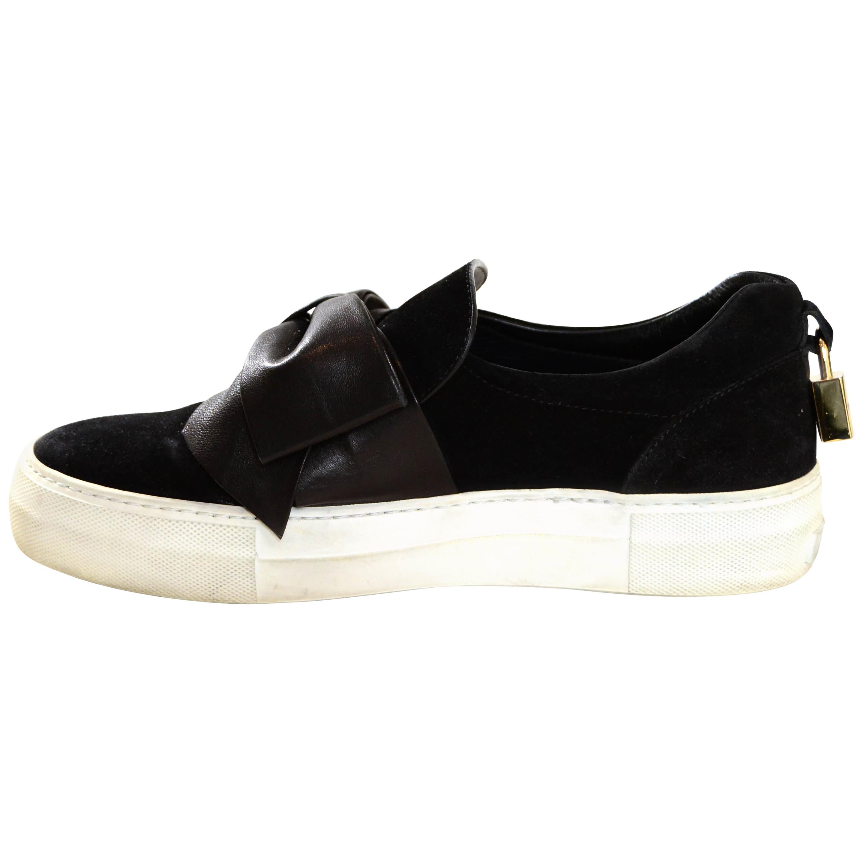 Buscemi Black Suede Sneakers w/ Bow Accents

Made In: Italy
Color:Black
Hardware: Goldtone
Materials: Suede, Leather
Closure/Opening: Slip on
Overall Condition: Very good - some scuffs to rubber platform
Includes: Goldtone lock at back

Marked Size: