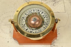 Liquid-filled compass on gimbal and mounted on mahogany wood plank