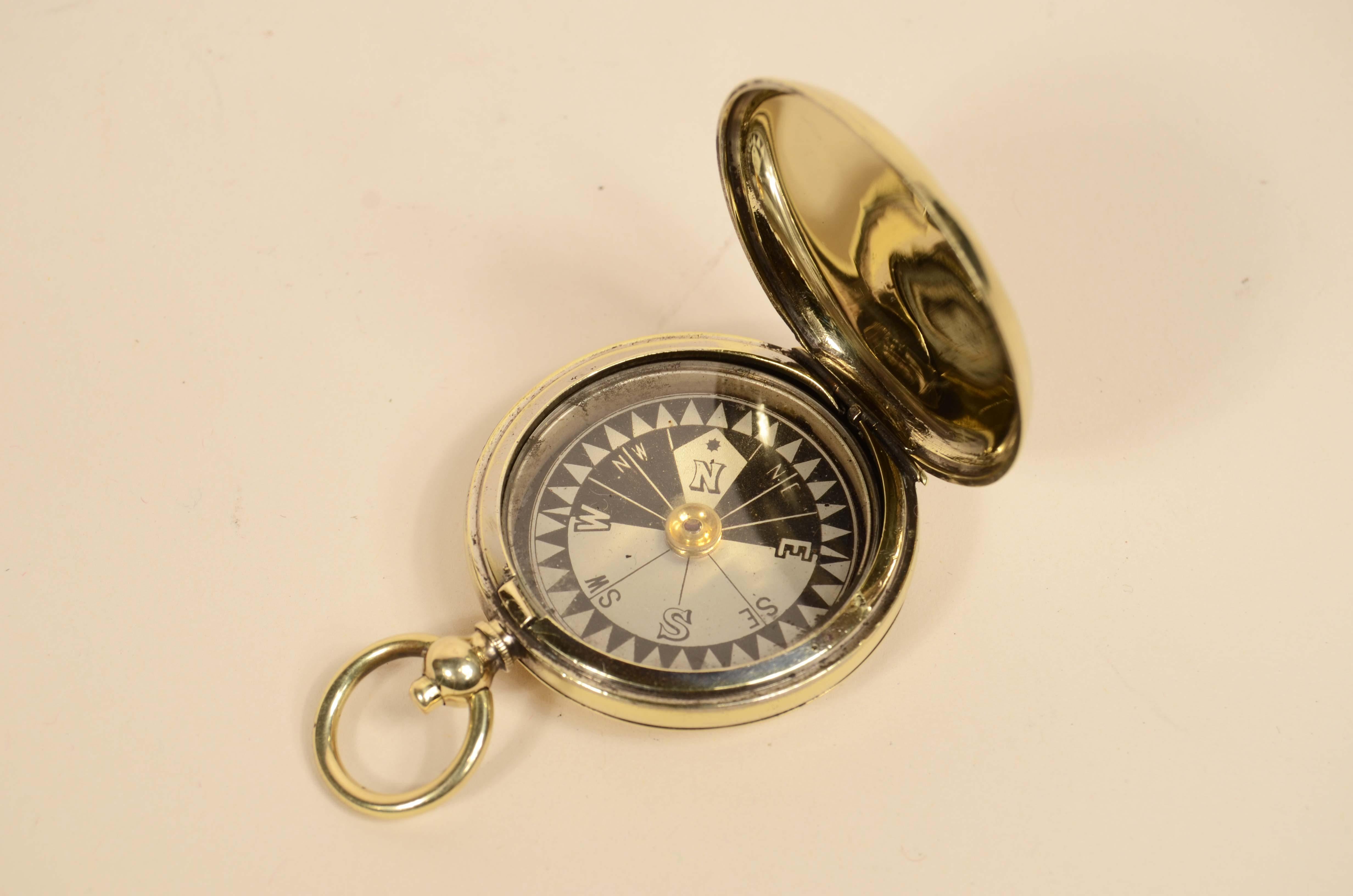 Boussole de poche d'officier de l'armée de l'air britannique signée E. KOEHN Genève Suisse V  de 1915 en laiton en forme d'horloge oignon. La boussole est équipée d'un couvercle à pression avec un bouton de déverrouillage à l'intérieur de l'anneau,