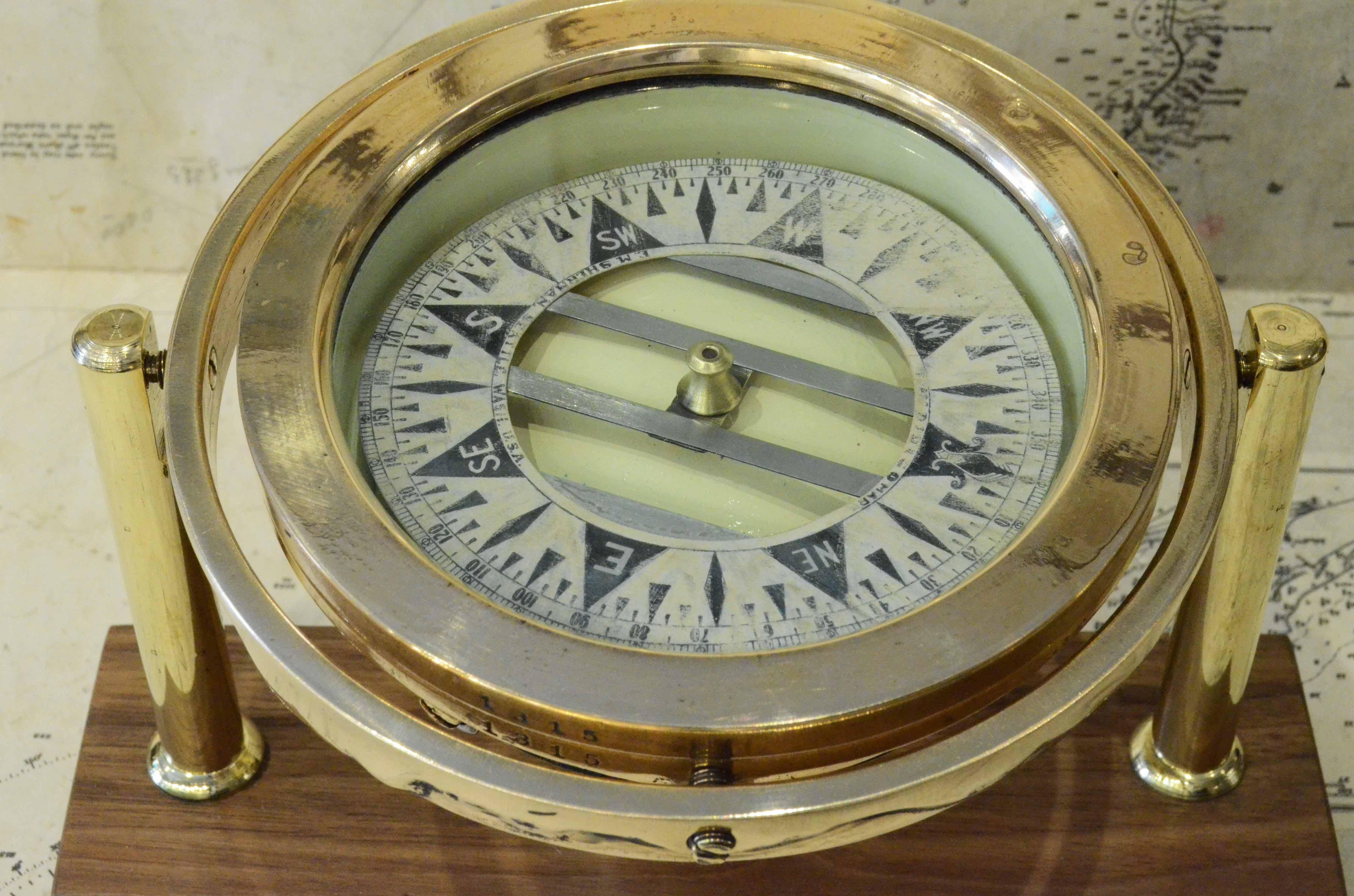 Nautischer Kompass auf Kardan signiert DIRIGO Eugen M. Sherman Seattle USA 1920er Jahre, montiert auf maßgefertigtem Walnuss- und Messingbrett. Acht-Zwanzig-Rose mit Winkelmesser-Kreis. Der Kompass besteht aus einem zylindrischen Gefäß aus Messing