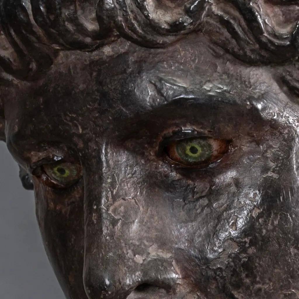 Dieser skulptierte Kopf des Apollo ist direkt von dem berühmten Kopf von Benevento inspiriert, der im Louvre-Museum aufbewahrt wird. Die in Herculaneum entdeckte und in griechisch-römischer Zeit entstandene Reproduktion interpretiert eine