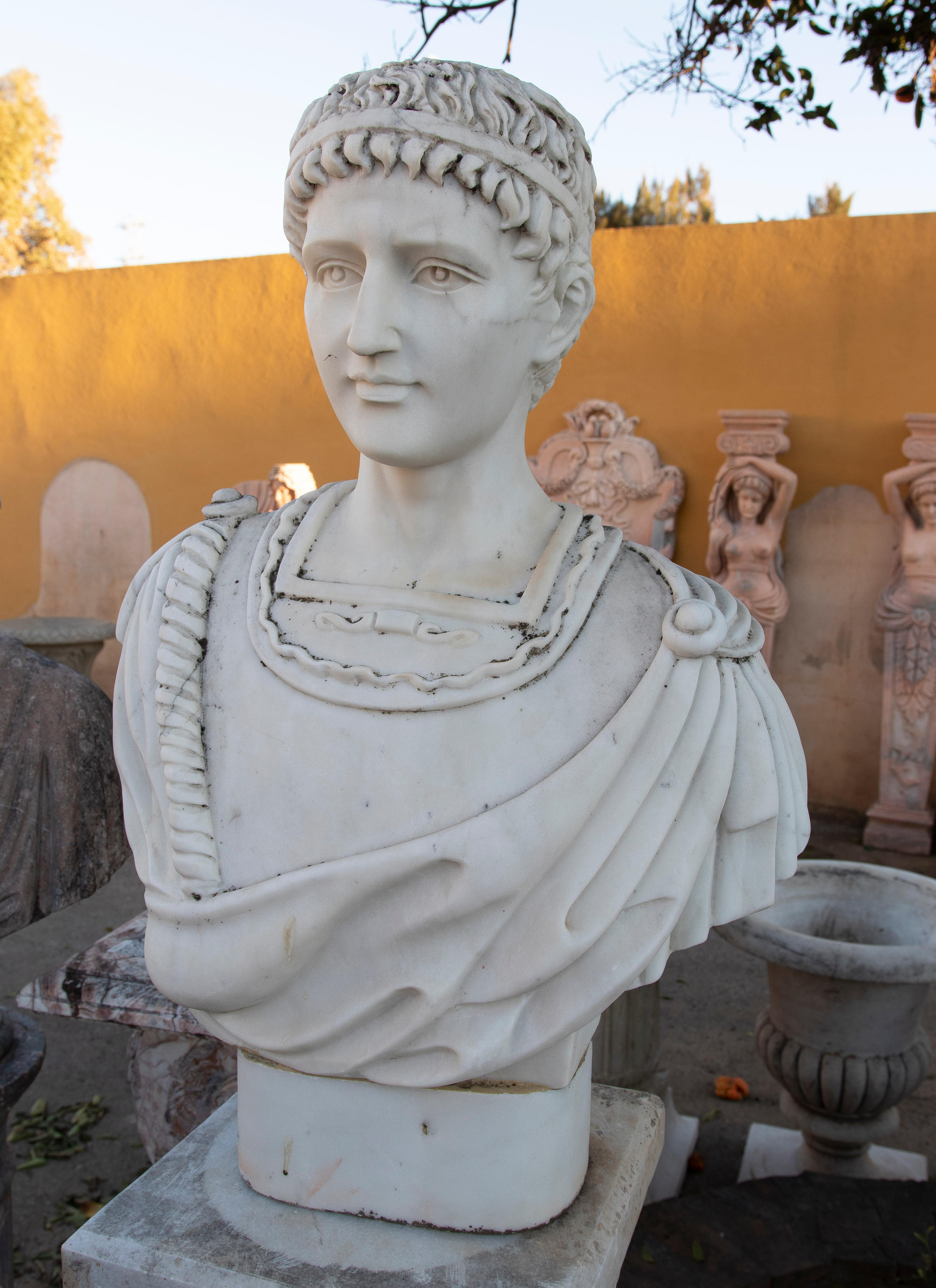 Bust of a Roman character with toga, hand carved in white marble.