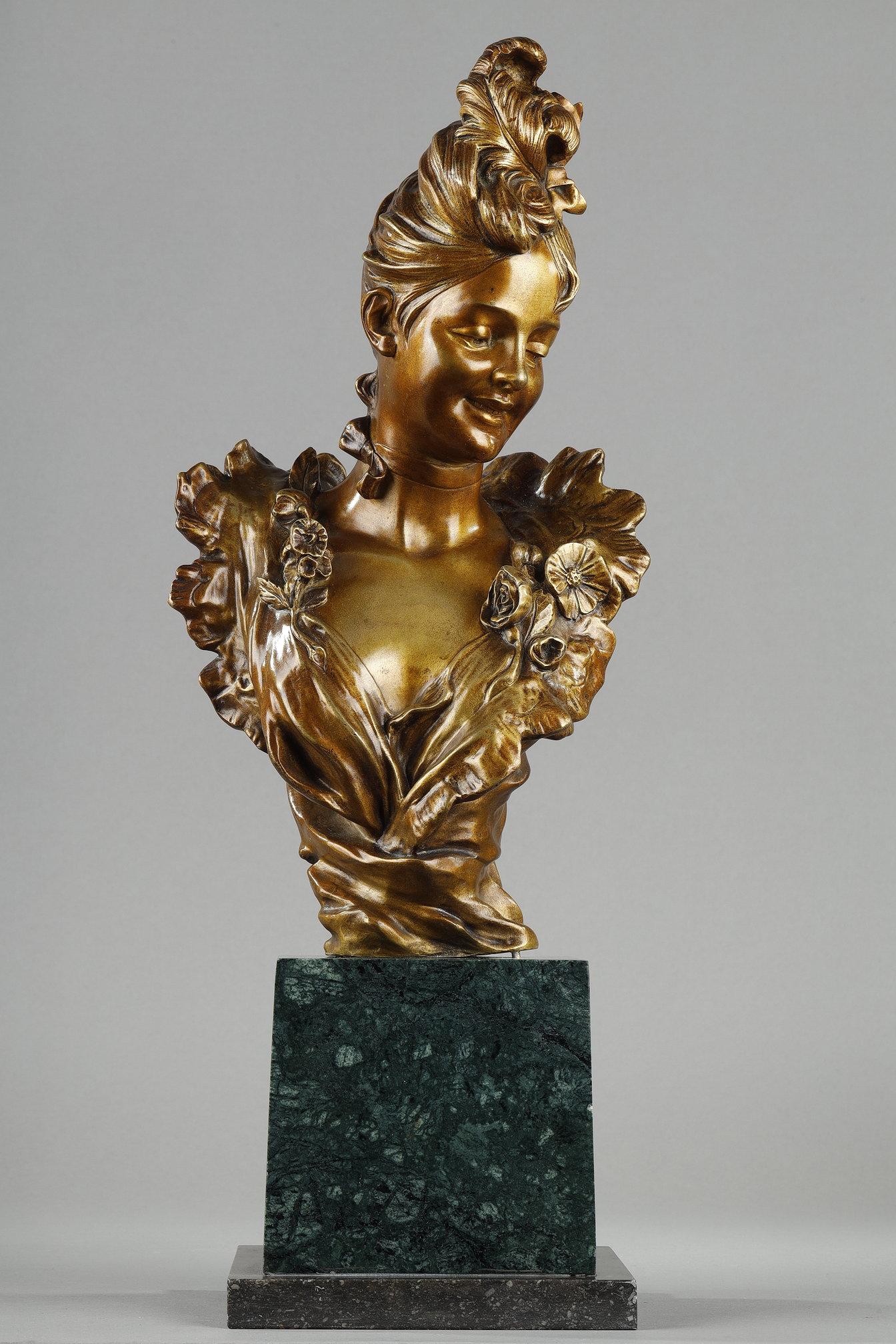 Bust of a young woman from the Belle Epoque period, in bronze with a golden patina, resting on a green Alpine marble pedestal on a grey sainte Anne counter pedestal. The smiling young woman is wearing a ribbon tied around her neck, and her hair is