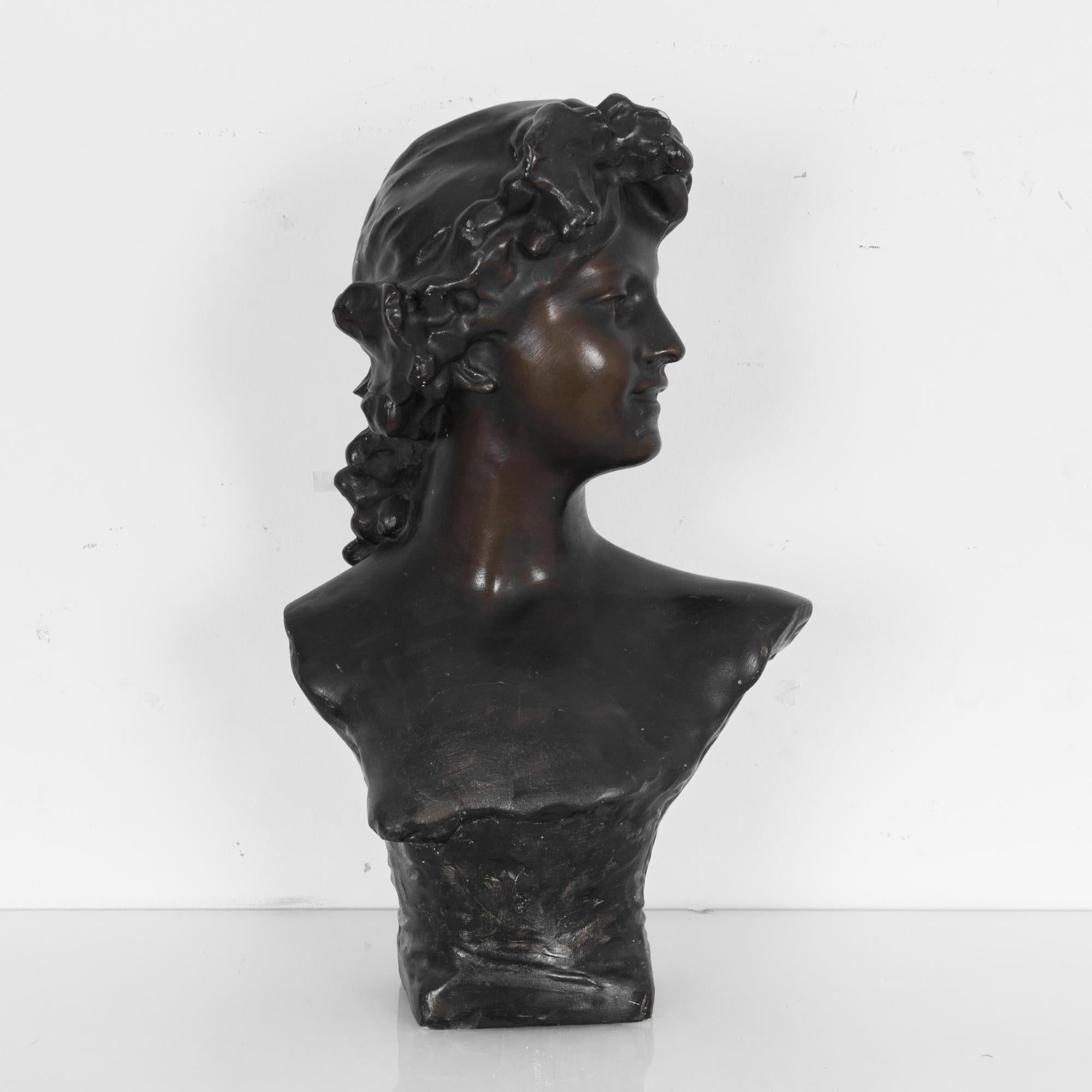 This plaster bust, painted with in faux bronze, was made in Belgium, circa 1910, and is an excellent reproduction of a work by the influential Flemish sculptor Jef Lambeaux. The bust has a lovely, dark patina and shows a serene and confident young