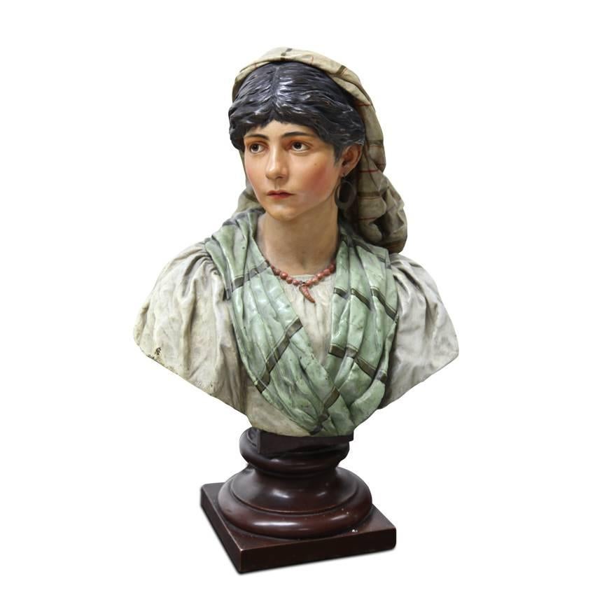 Polychrome painted bust of a young female in Provincial clothing. The bust is signed Jul. Seidler, Karlsruhe, 1890. One earring is missing.