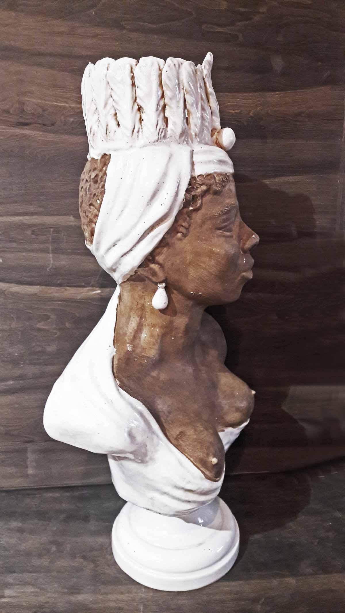 A terracotta and porcelain bust of an African woman in traditional headdress, from France, circa 1940.
