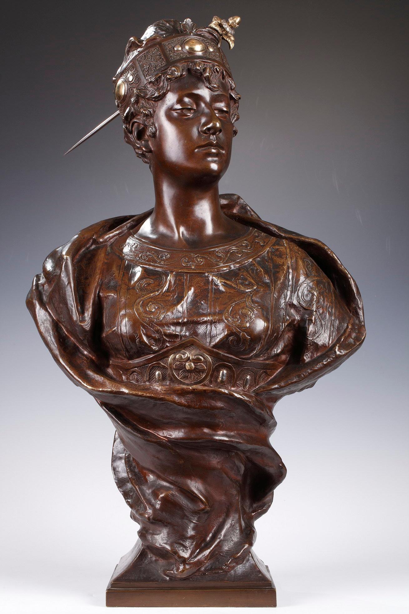 Signed G. Leroux and foundry seal E. Blot Paris.
Rare bust in patinated bronze representing a young women wrapped in a drapery and dressed in an oriental-inspired tunic with interlacing patterns and a large belt with silver and gold highlights. Her