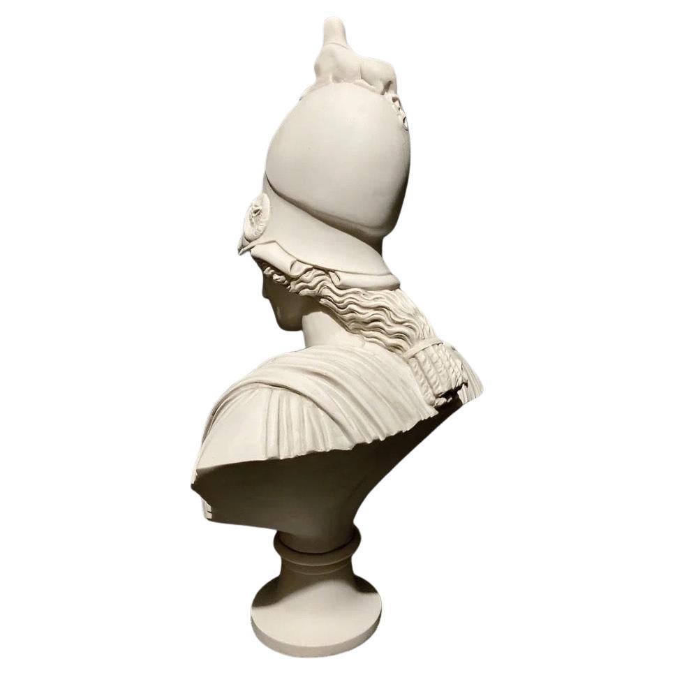 Ce buste d'Athéna, déesse grecque de la sagesse et de la guerre, datant du XXe siècle, est un hommage à la sculpture grecque classique. Représentant Athéna avec son casque emblématique, la pièce met en valeur son expression posée et dominante,
