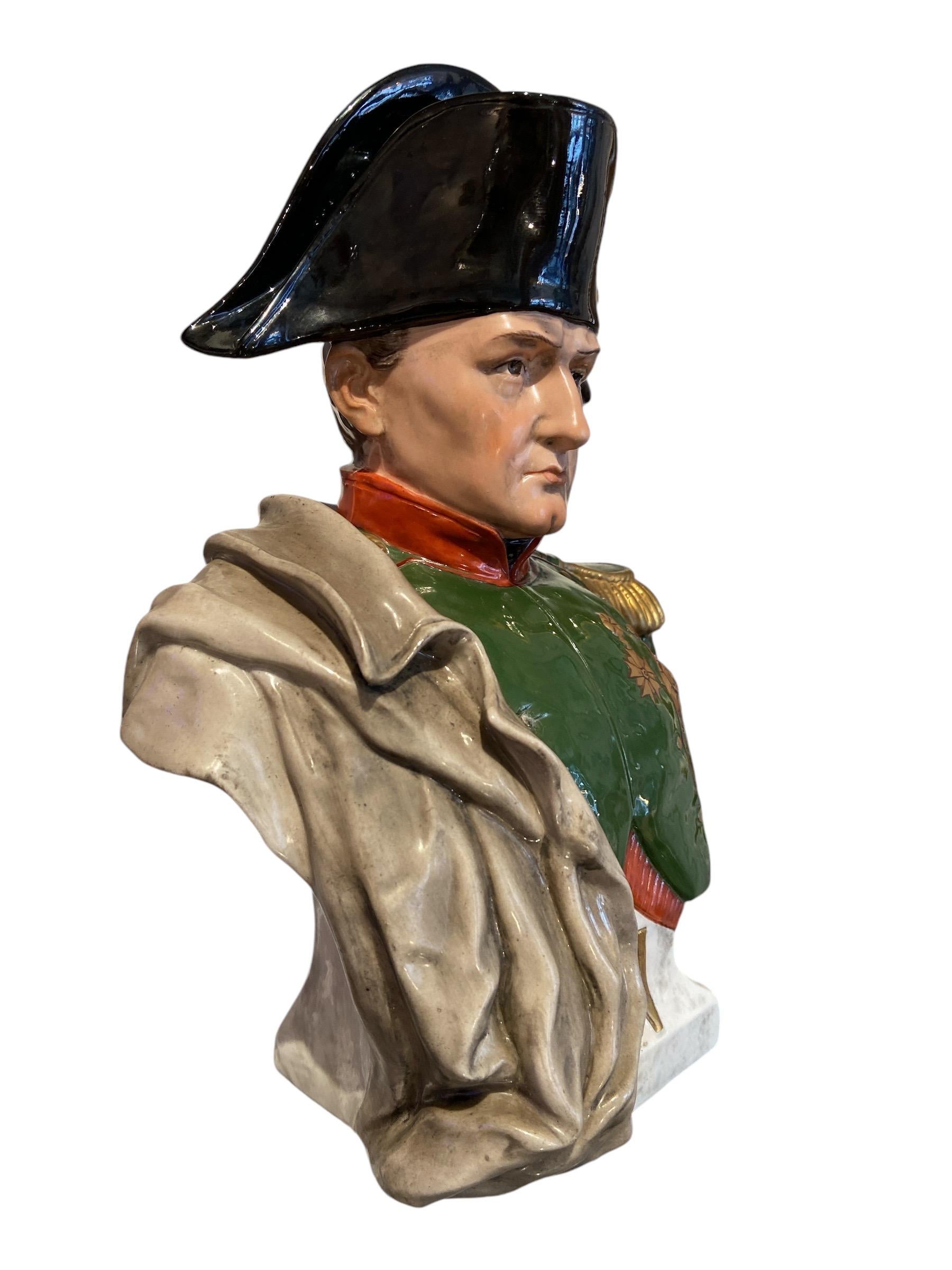 Busto di Napoleone Bonaparte di Sitzendorf, in porcellana, dipinto a mano.
Esempio dettagliato dell'Imperatore, vestito con cappello bicorno,
uniforme verde con medaglie, drappeggiata con un cappotto. 
Sulla base del piedistallo c'è una 