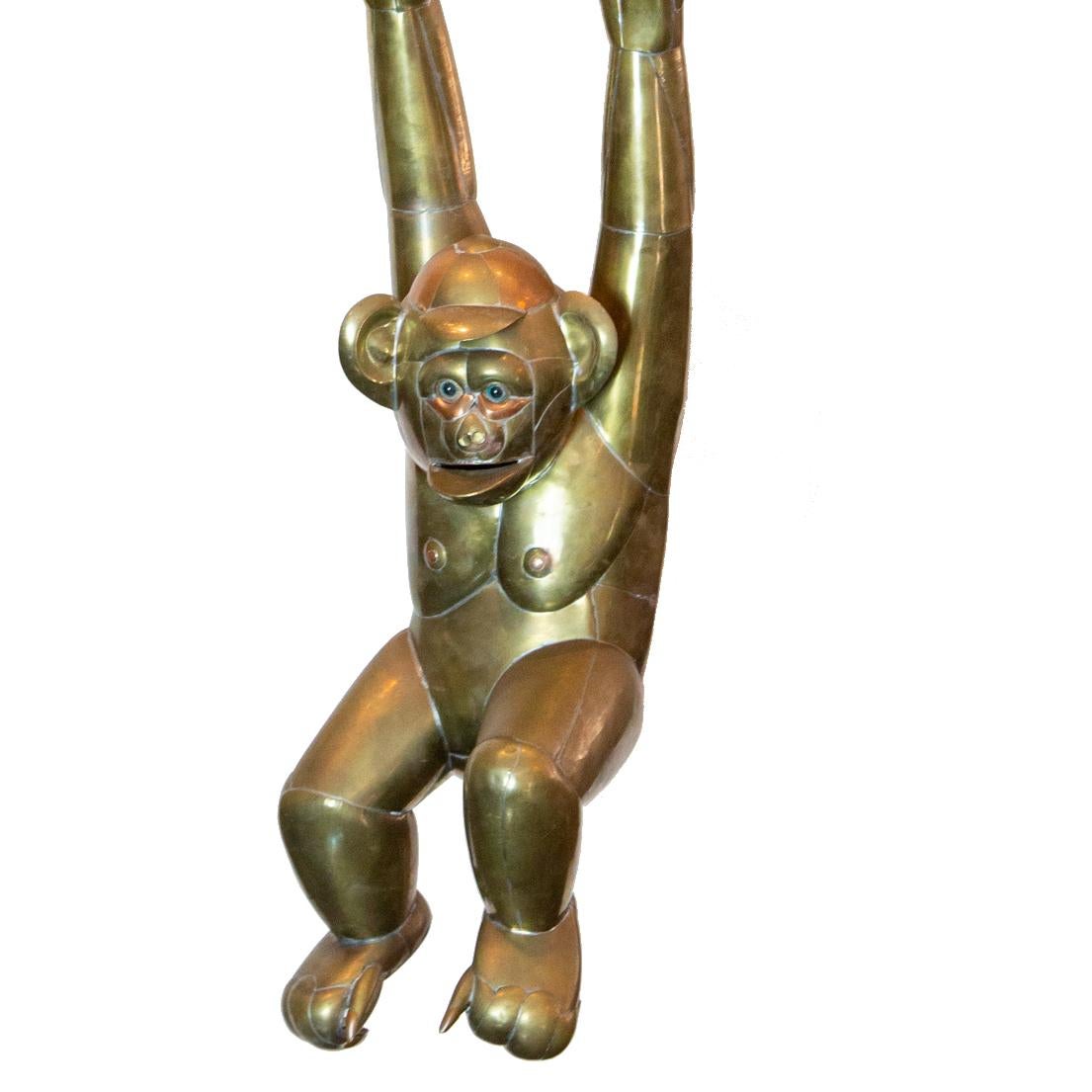 Bustamante hanging brass monkey with baseball cap. Large scale brass monkey by Sergio Bustamante, circa early 1970s. This whimsical yet detailed example hangs effortlessly from its brass branch with leaf details. Measures: 36