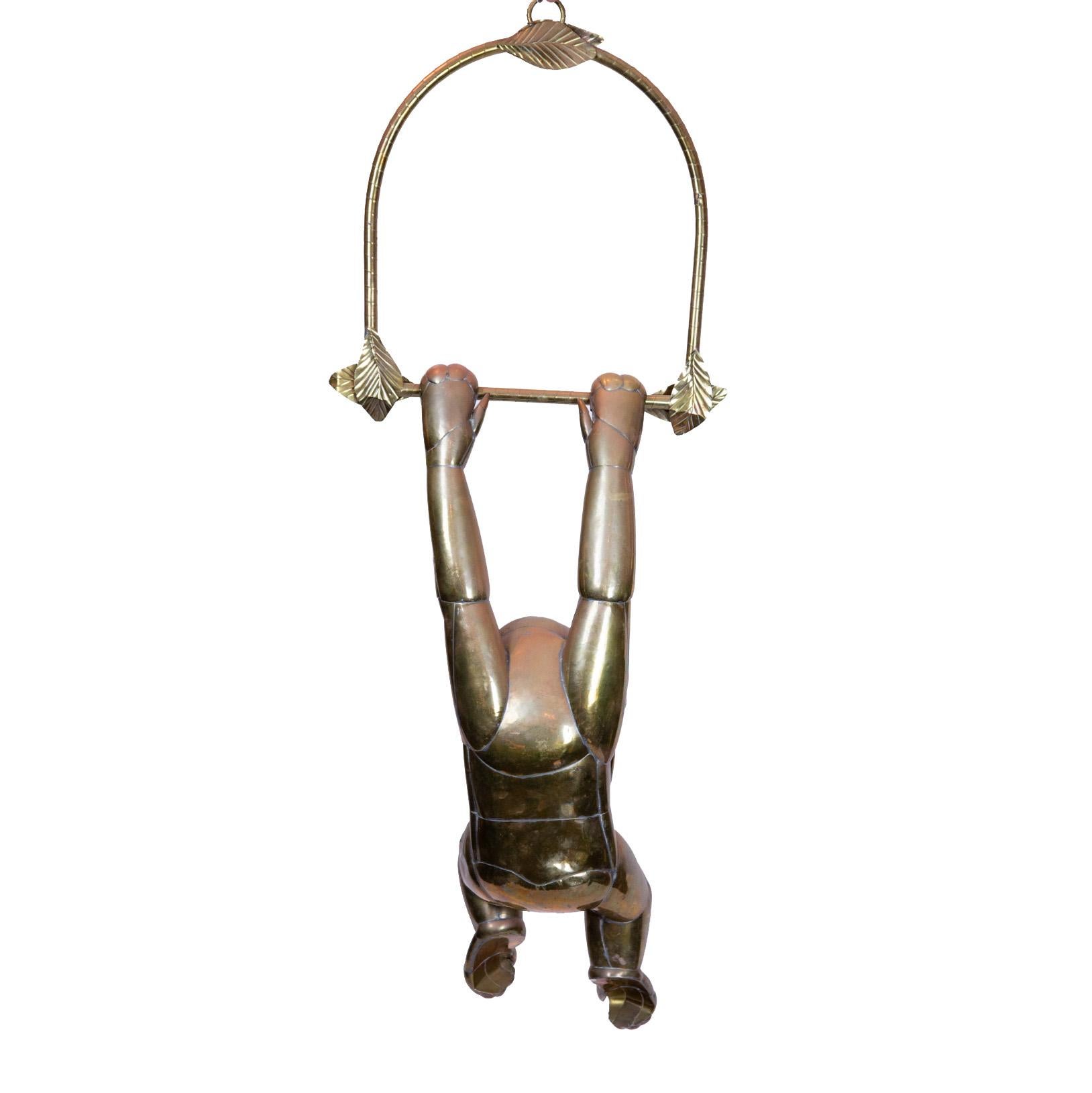 Bustamante hanging brass monkey with baseball CAP. Large scale brass monkey by Sergio Bustamante, circa early 1970s. This whimsical yet detailed example hangs effortlessly from its brass branch with leaf details.