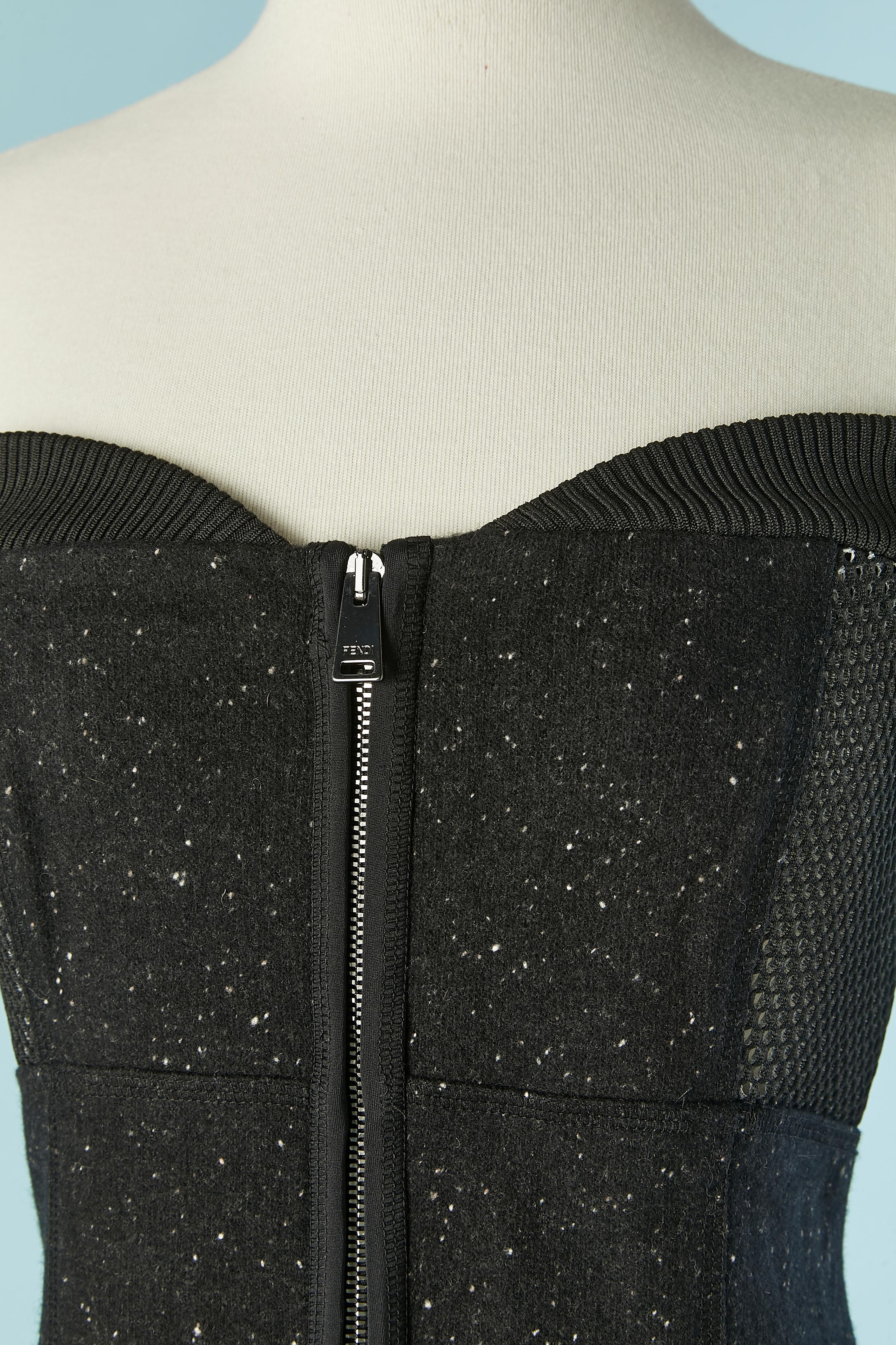 Abito bustier in lana chiné e tessuto tecnico trasparente sul lato. Nessun cartellino di composizione del tessuto (probabilmente questo abito è un prototipo) 
Chiusura con zip e gancio sulla parte centrale del davanti. Non c'è fodera, ma