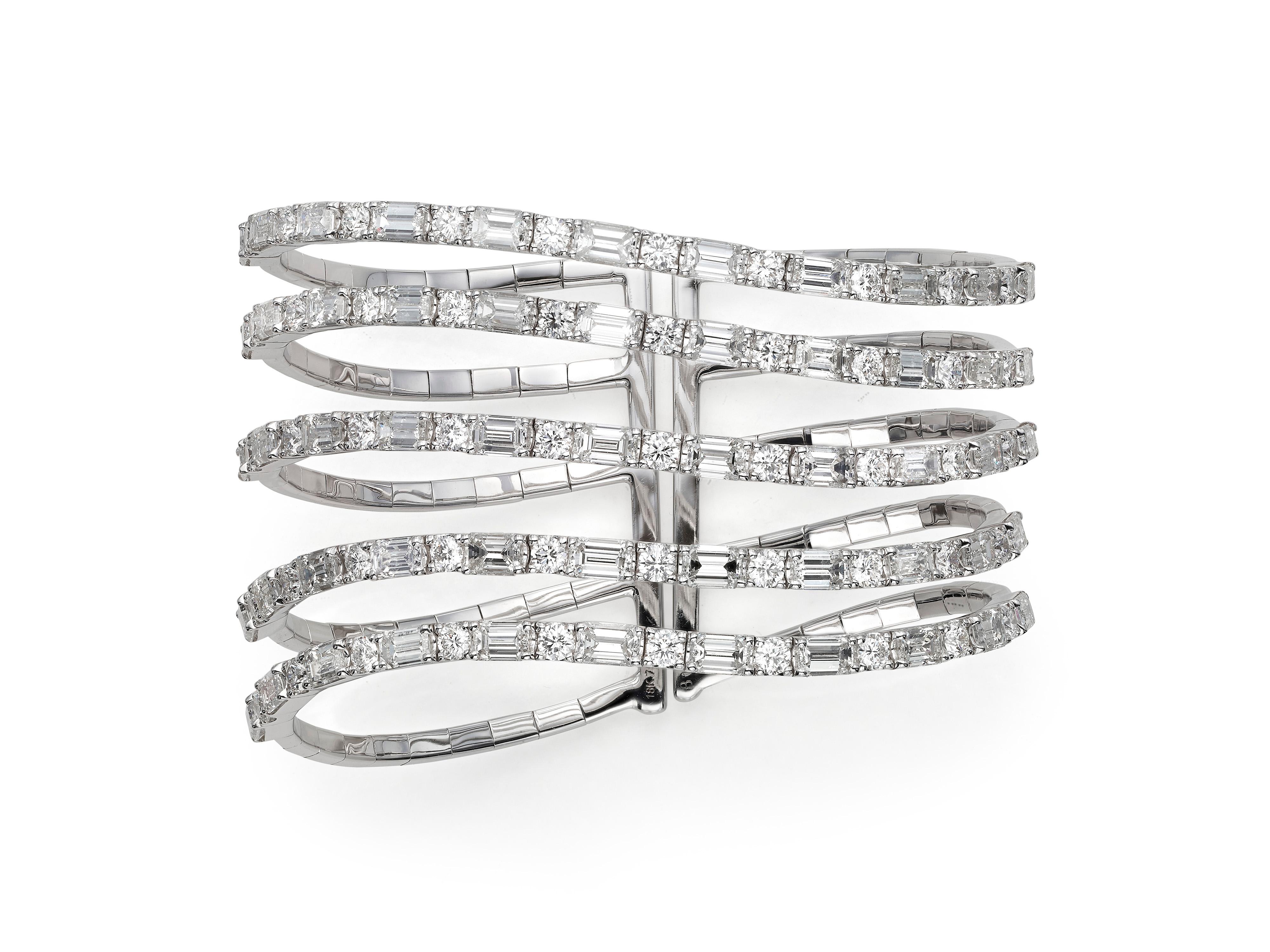 This exquisite cuff bangle is crafted from sleek 18K white gold and is encrusted with 17.66 carats of diamonds.  The five row spring design wraps delicately around your wrist as it glistens in the light.  Wear yours to your next big event for