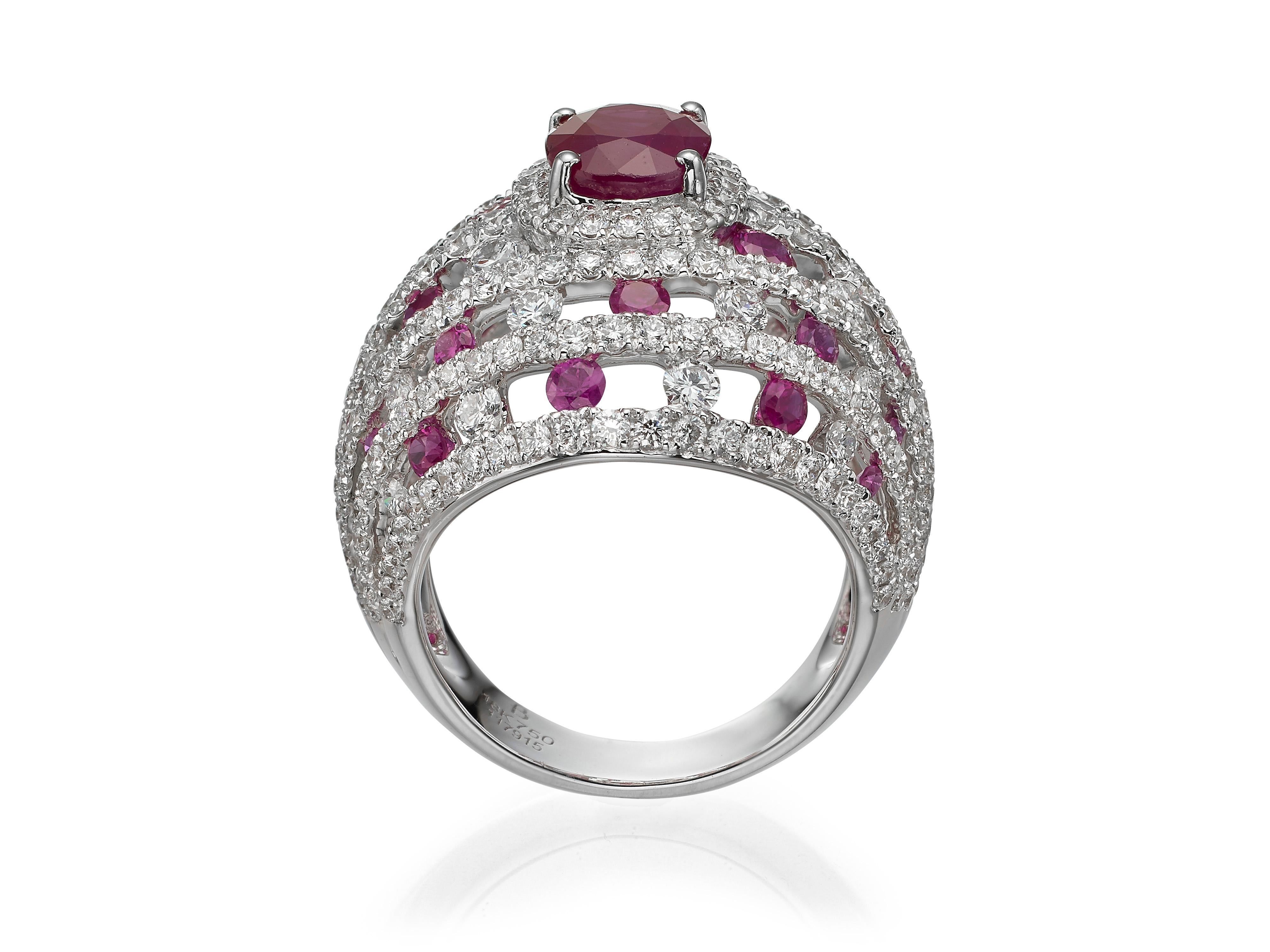A breathtaking 2.23 carat oval ruby is surrounded by a halo of alternating round rubies and diamonds.  Set in 18K white gold.
Currently a ring size US 7.  For other sizes, please contact seller. 

Composition:
18K White Gold
1 Oval Ruby: 2.23