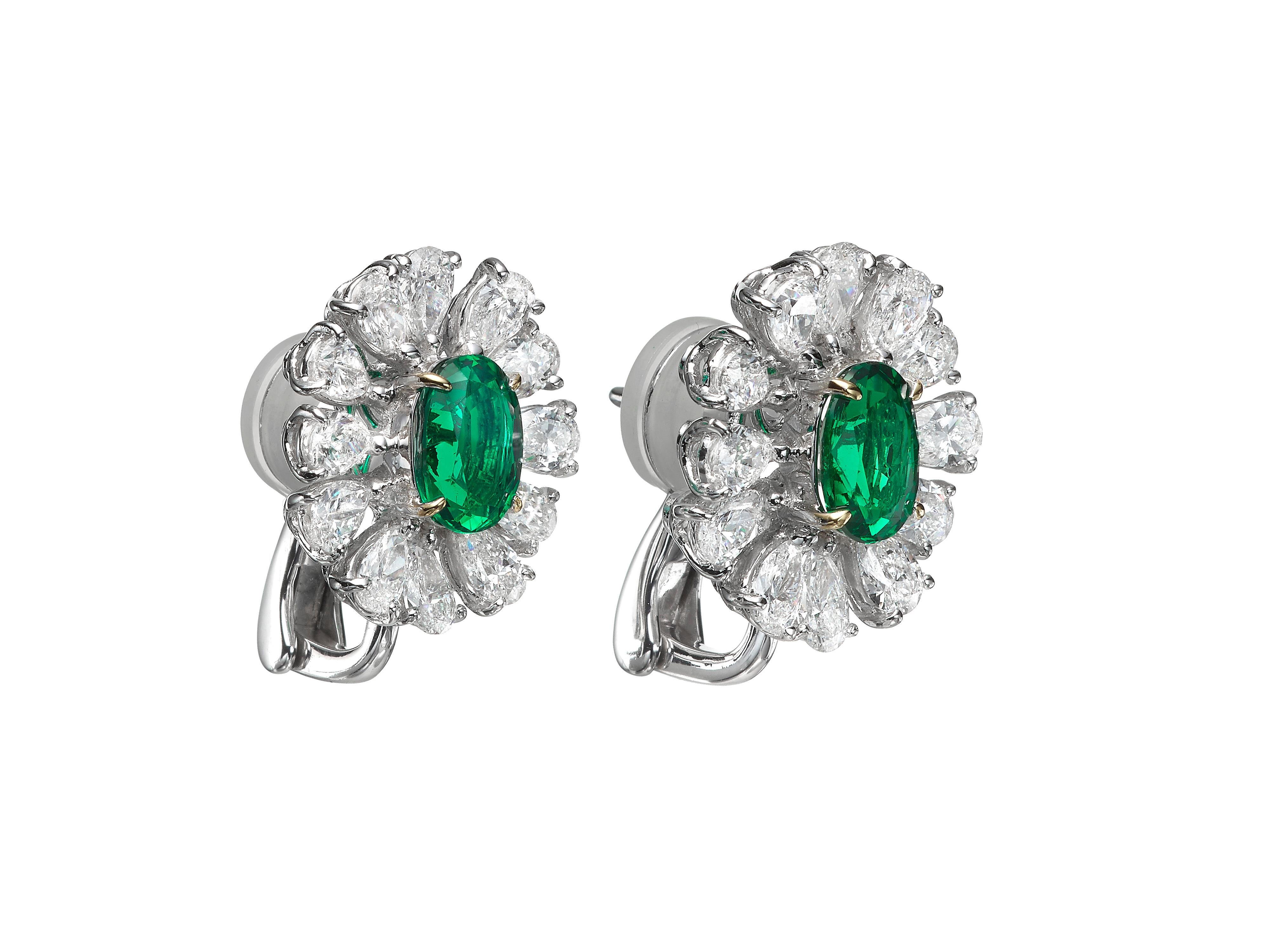 Understatedly elegant diamond stud earrings feature a center oval Emerald accented by a halo of pear-shape diamonds.  Total emerald weight 2.51 carats.  Total diamond weight 3.52 carats.  In 18k white gold.  This design is also available in Butani