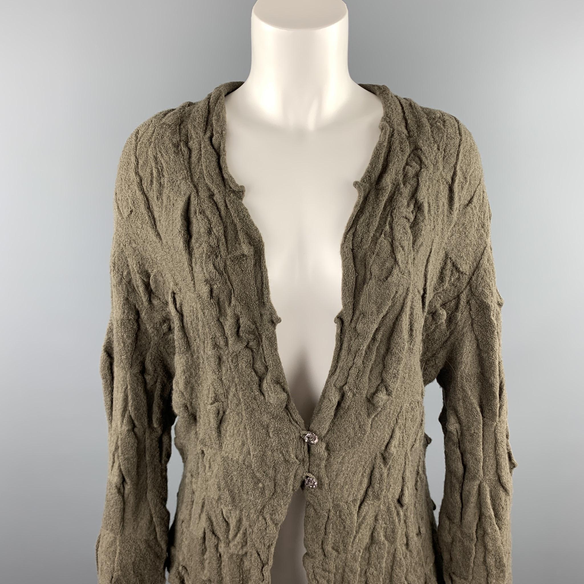 BUTAPANA cardigan comes in a olive knitted textured wool featuring a scalloped hem and a buttoned closure. Made in Japan.

Good Pre-Owned Condition.
Marked: No size marked

Measurements:

Shoulder: 17 in. 
Bust: 40 in. 
Sleeve: 27 in. 
Length: 23.5