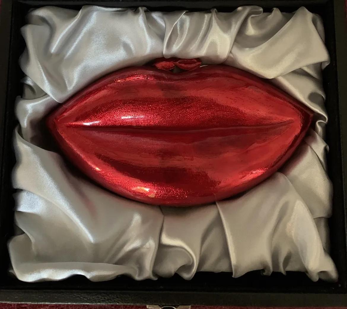 
A fantastic bag by Butler & Wilson .


Superb design and now cannot purchase anywhere.


It's made from enamel and is the shape of bright red lips.


It lays in a grey satin large case, which it came with when purchased .


Beautifully made and in