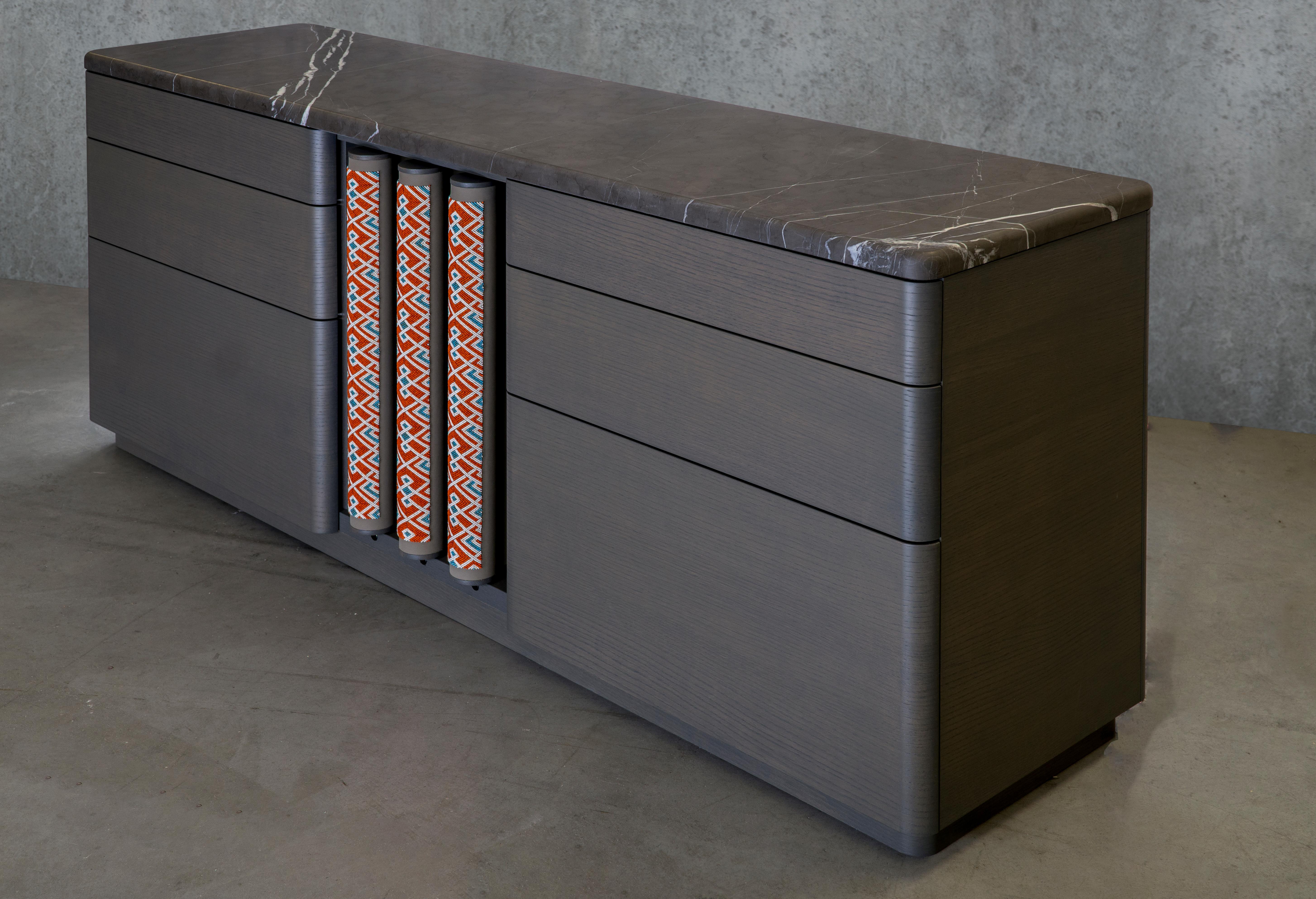 This credenza from the SoShiro Pok collection is an oak veneer storage unit embellished with intricate and complex beading artistry, leather, and marble top. The beadwork is done on fine Italian nubuck leather panels that are then upholstered onto a