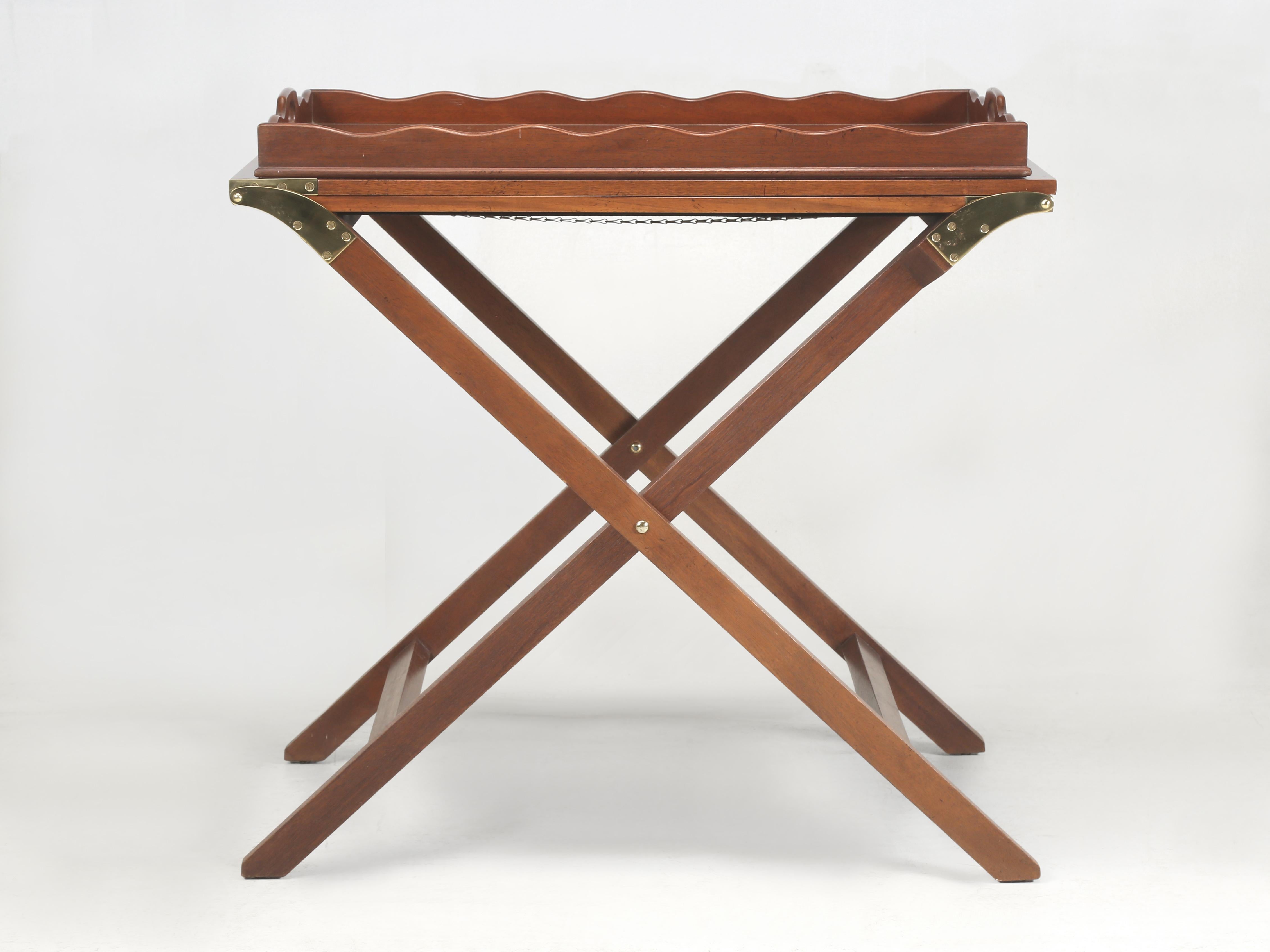 Butler tray table, with a folding X-base; made from Book-Matched Solid Mahogany in Superb Craftsmanship and still in Excellent condition. Our Butler Tray Table was built in Michigan by the Baker Furniture Company when they were known as one of the