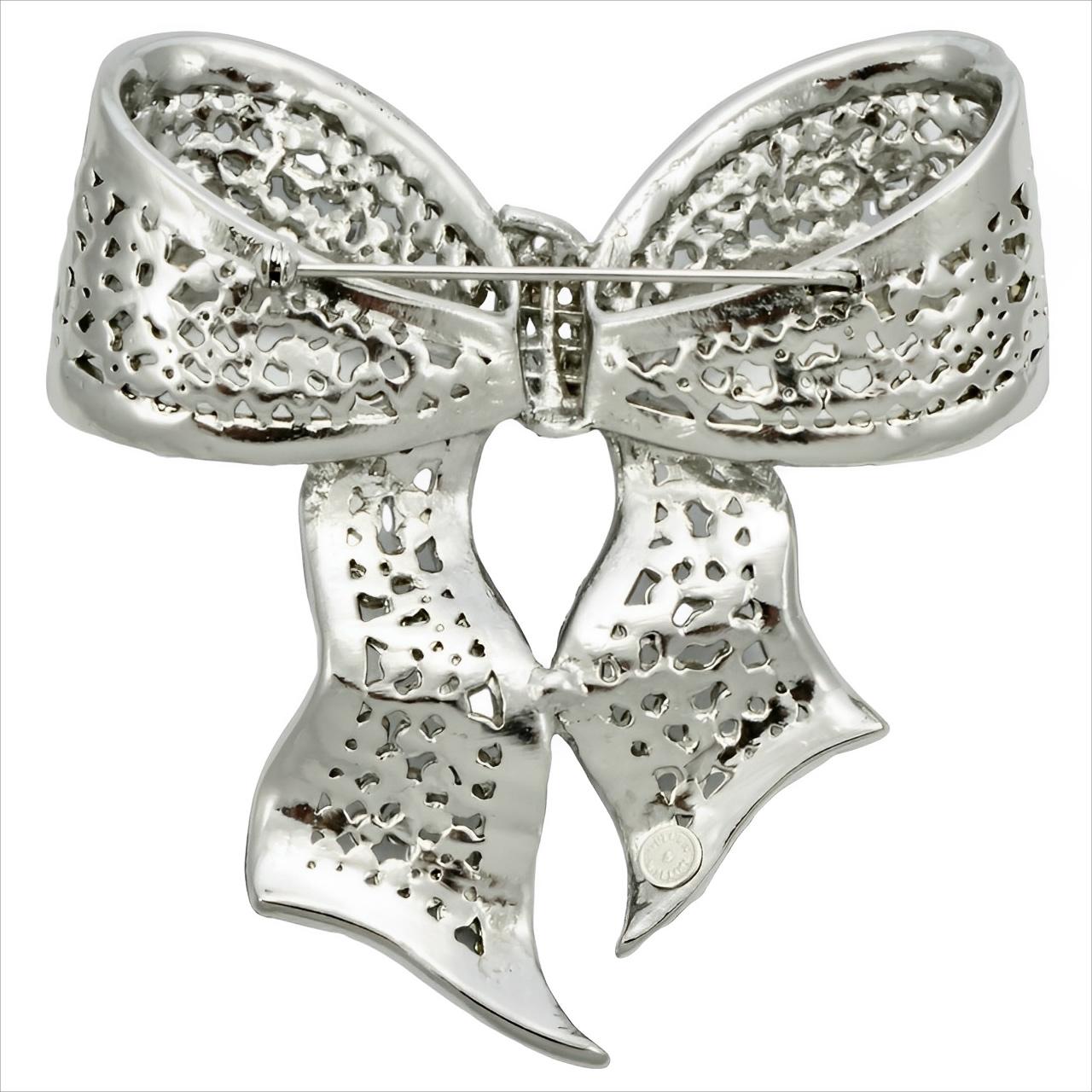 Fabulous Butler & Wilson silver plated bow brooch featuring clear crystals with a pastel aurora borealis crystal edging. Measuring maximum width 8.5 cm / 3.34 inches by maximum length 9.4 cm / 3.7 inches. The brooch is in very good condition.

This