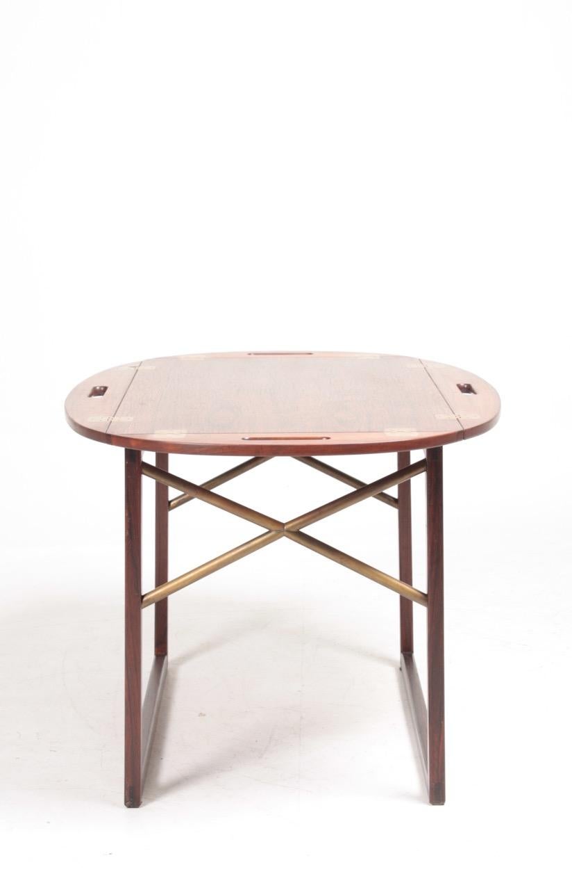 Stunning end / tray table in rosewood with brass hardware. Designed and made by Svend Langkilde of Denmark in the 1960s. Great original condition.