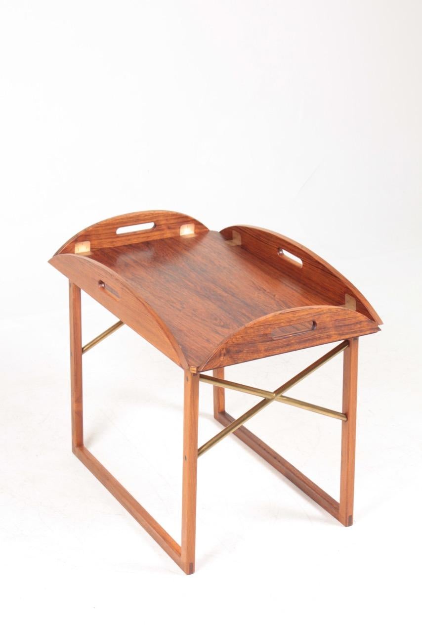 Stunning end / tray table in rosewood with brass hardware. Designed and made by Svend Langkilde of Denmark in the 1960s. Great original condition.