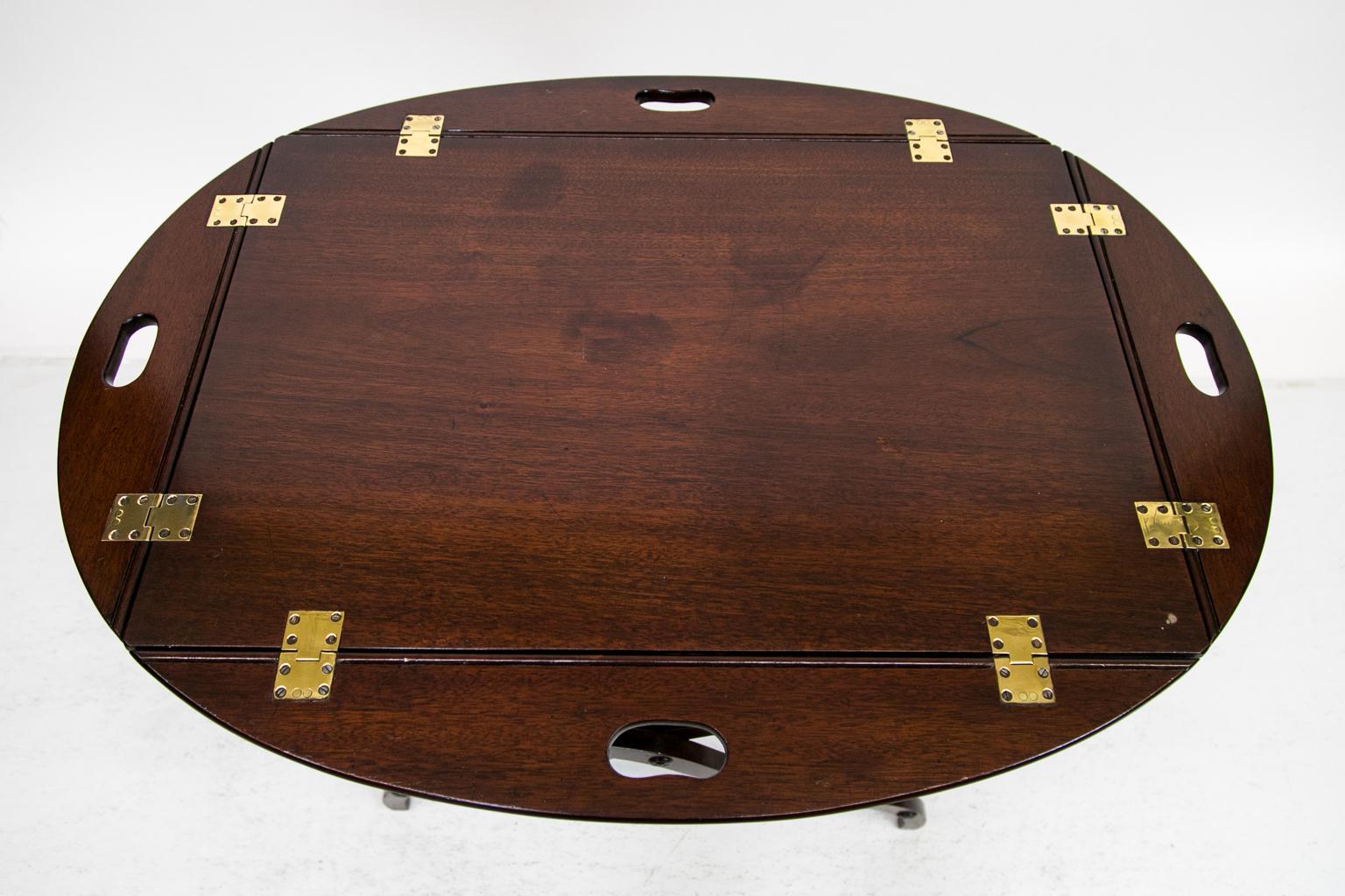 Dieser Butler-Tisch hat die originalen Messingscharniere, die für eine einfache Wartung poliert und lackiert wurden. Auf einer Seite der Platte befindet sich eine zehn Zentimeter lange Einkerbung, das Tablett ist an den Beinen befestigt.
    