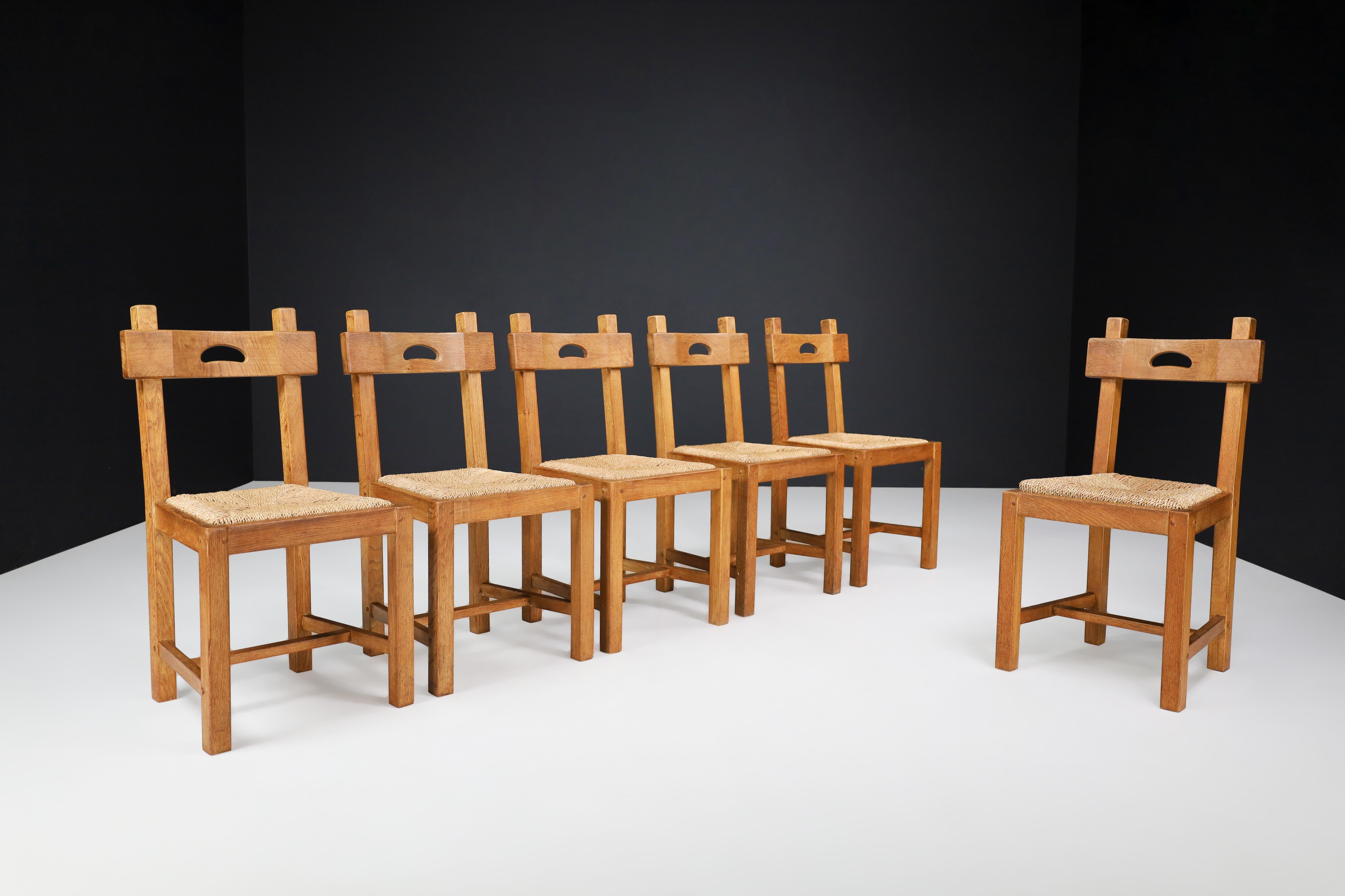 Butralist Dining Chairs in Oak and Rush, France 1960s.

This set of six dining chairs from France, crafted from oakwood and rush in the 1960s, boasts a warm, rich color that has developed a lovely patina over time. The chairs are not only