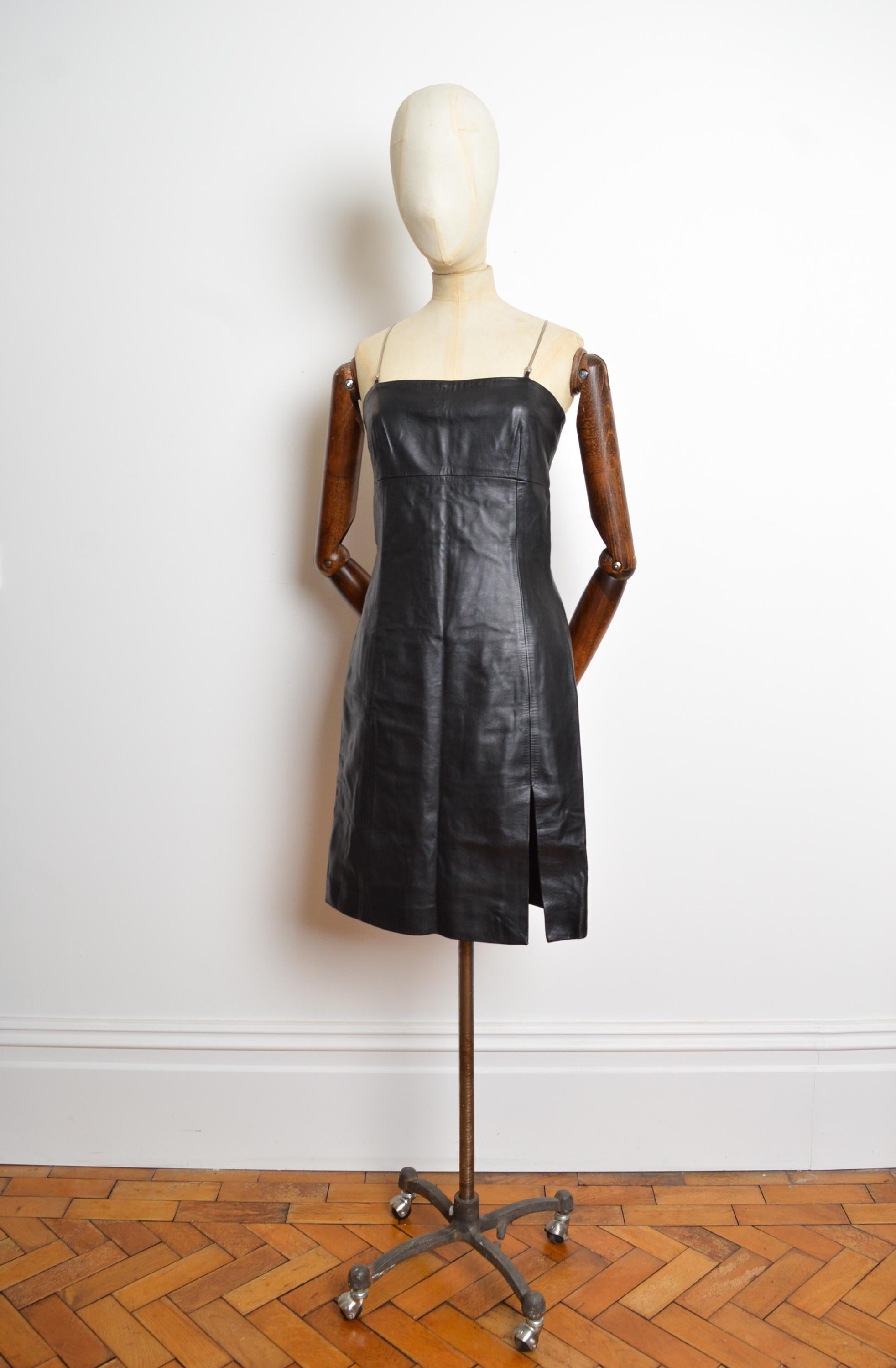 Este fabuloso y sexy LBD de Donatella para VERSACE está confeccionado con un exterior de piel suave como la mantequilla, con hombros de tirantes estilo espagueti en color cromo y detalles del icónico logotipo de Medusa en la parte delantera y