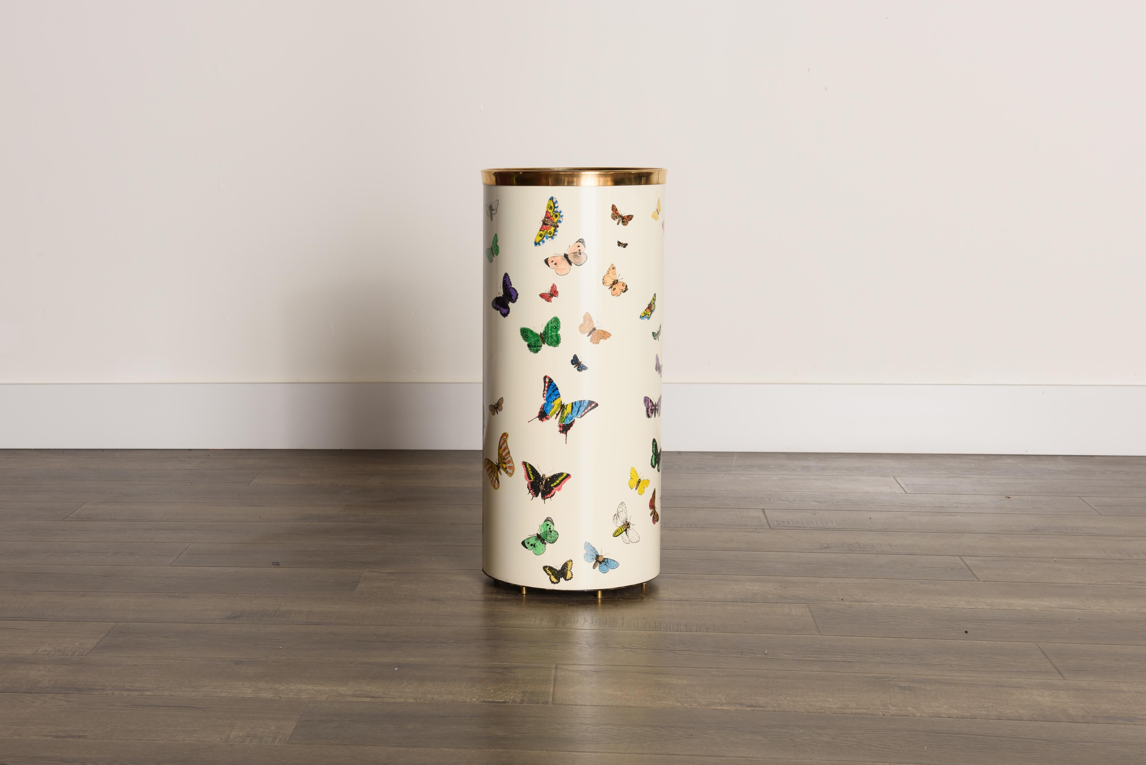 This rare and coveted collectors item is the 'Farfalle' (translated to 'Butterflies') umbrella stand by Piero Fornasetti, circa 1960s, signed underneath. This hefty round umbrella bin is made with lithographic transfer and lacquered metal that has a