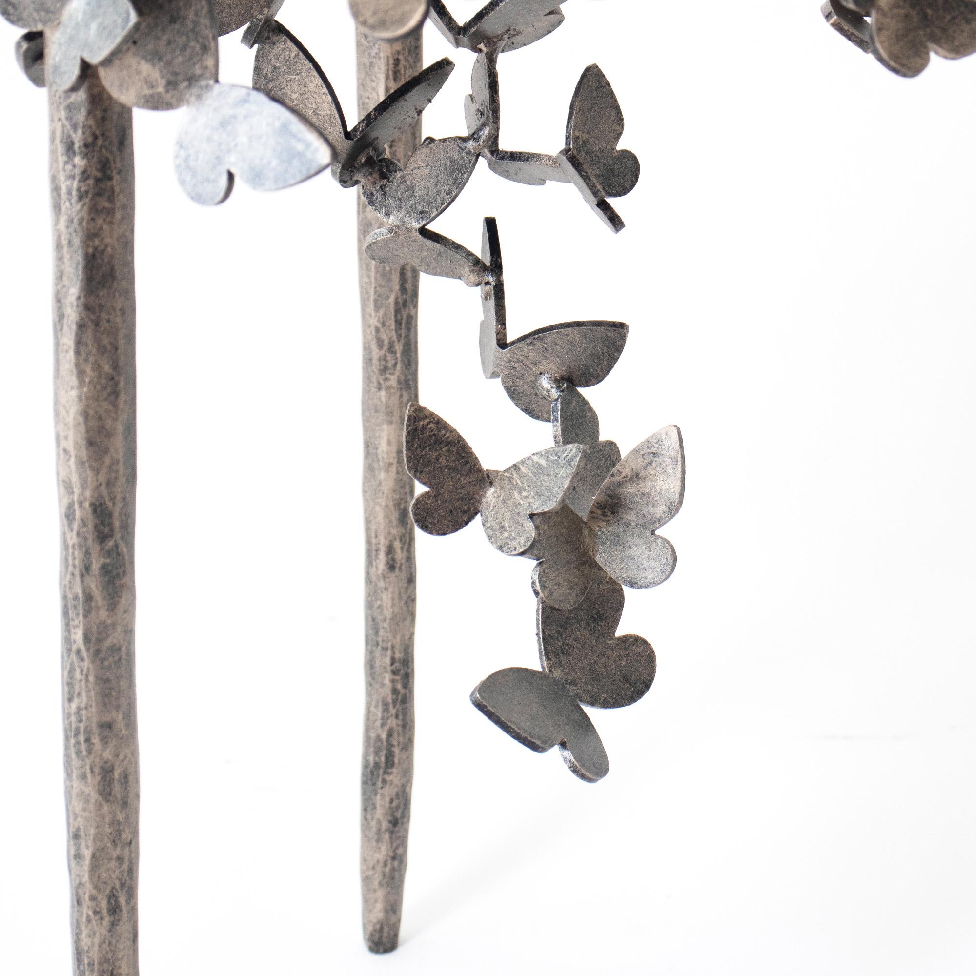 Embrace the delicate beauty of the Butterfly Accent Table, an enchanting piece that flawlessly marries form and function. The base of this table is crafted from hand-bent metal, mimicking the intricate and captivating shape of butterfly wings. Every