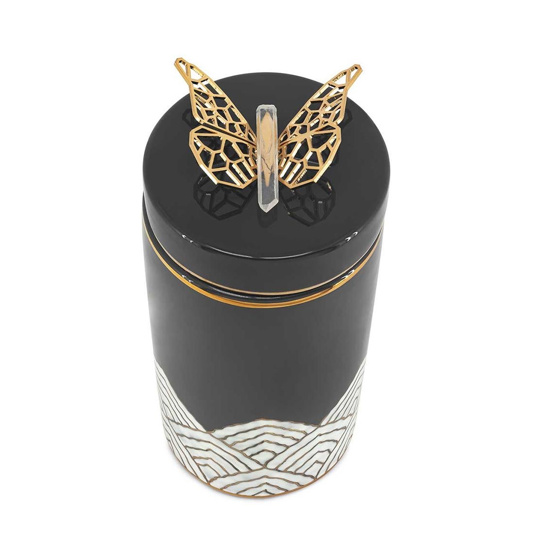Boîte papillon en céramique émaillée de couleur noire
finition. Avec de la céramique émaillée blanche au
fond avec une bordure dorée. Boîte avec couvercle avec
papillon en laiton poli sur le dessus du couvercle.
