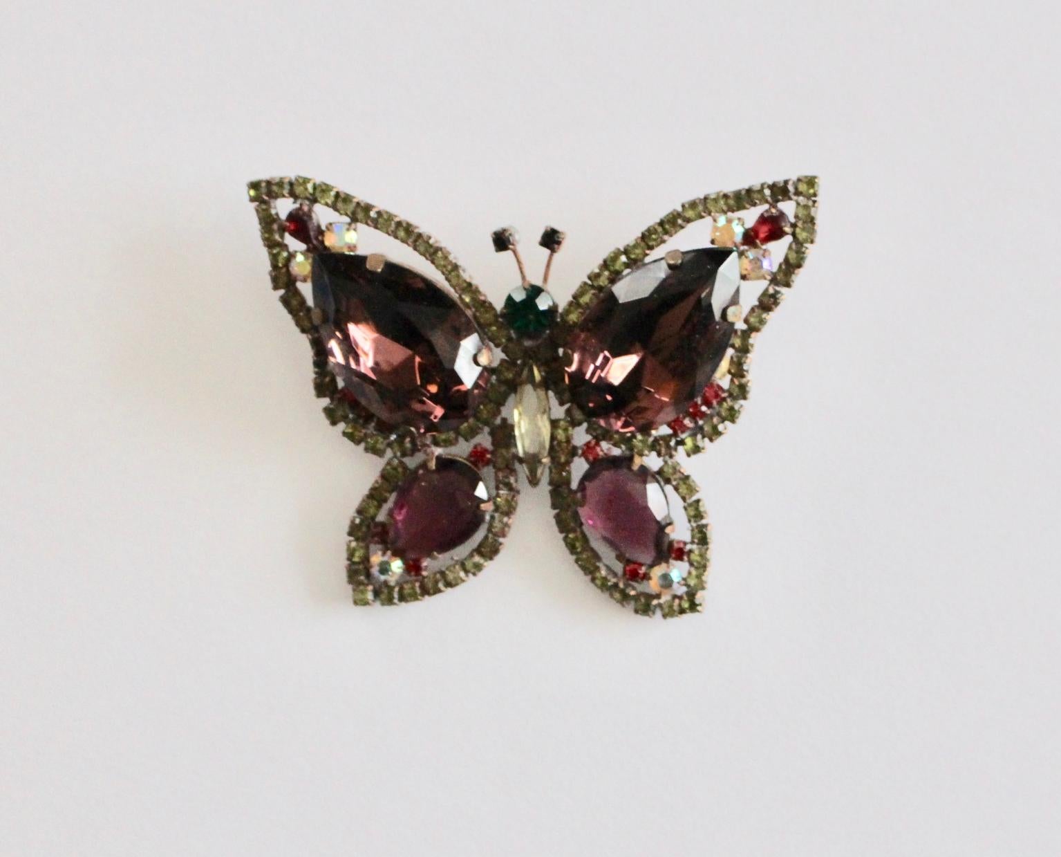 This presented butterfly brooch shows various size facetted stones in the colors lilac, green and red.
Also the stones are set on a light metal frame to create the structure.
The vintage condition is very good.
approx. measures:
height 6 cm
width