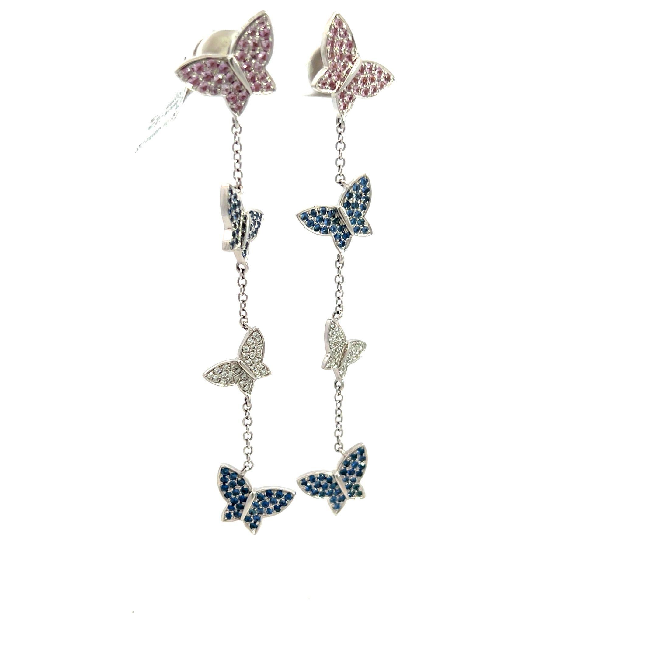 Butterfly Dangle Earrings crafted in 18K white gold. Each earring showcases a cascade of delicately suspended butterflies, adorned with a mesmerizing combination of sparkling diamonds and vivid sapphires, embodying the grace and beauty of