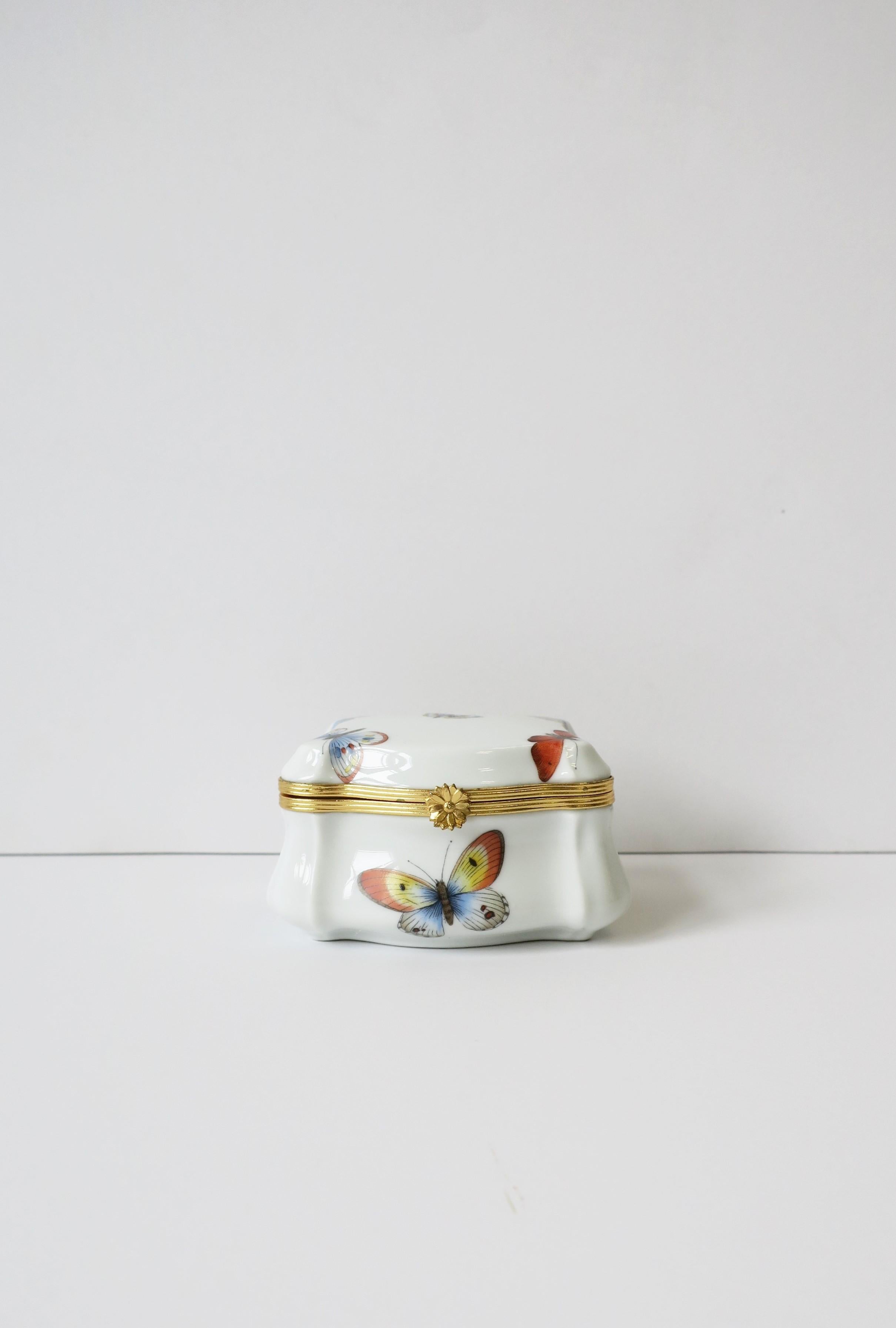 A beautiful French white porcelain and gold brass jewelry box with colorful butterflies, circa mid-20th century, Limoges, France. Great as a standalone piece or to hold jewelry or other small items on a desk, vanity, dresser, nightstand table, etc.