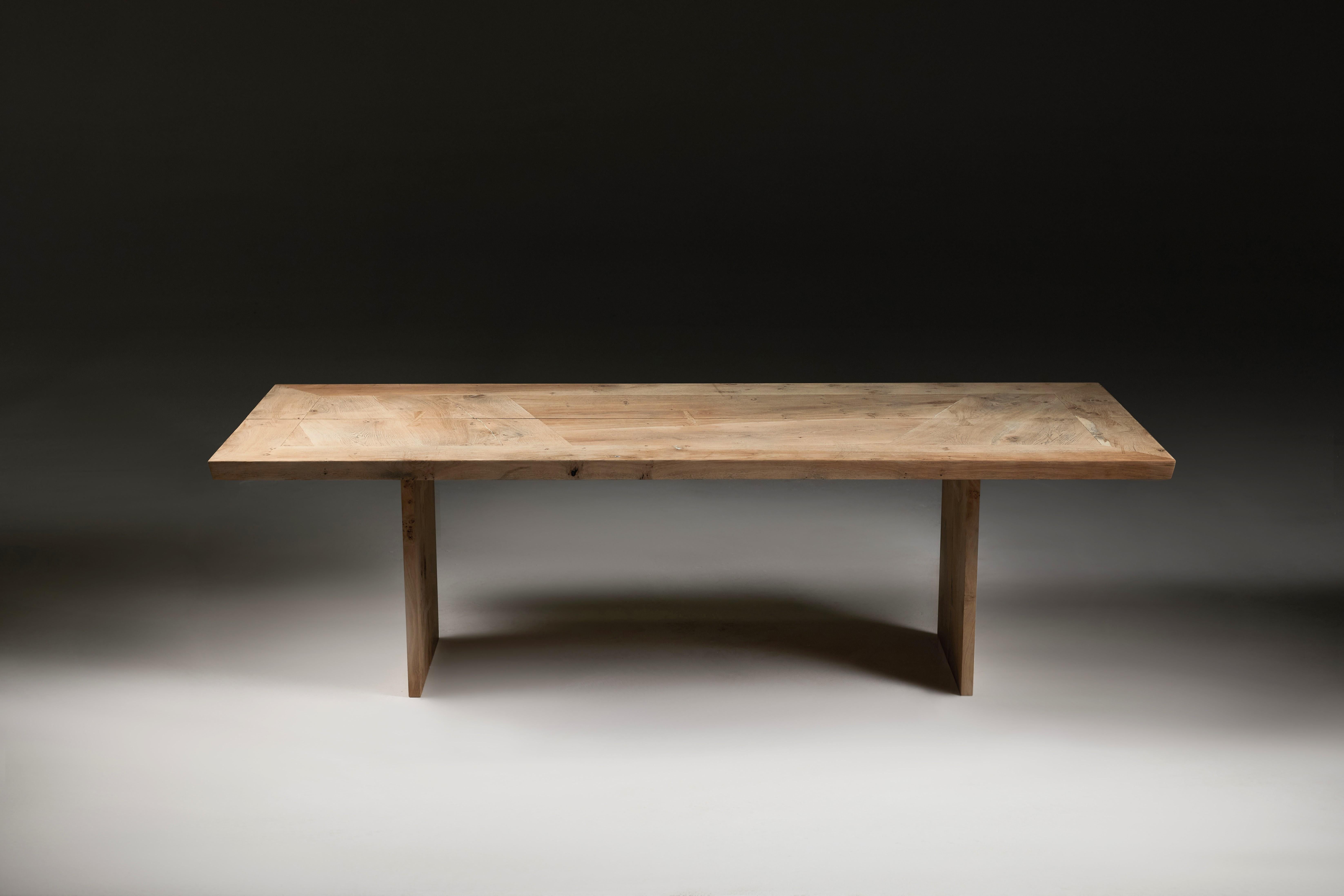 This table was made around 13 years ago and has returned to the workshop for re-imagining. The top is made from solid salvaged English oak slabs set within a mitred frame. It has been given a new pair of spaced butterfly-jointed legs that complement