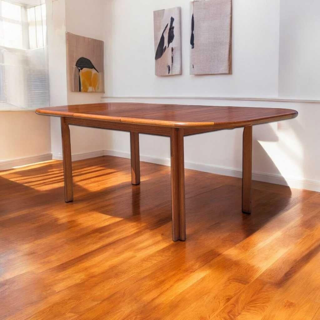 Une table de salle à manger distinctive dans la tradition scandinave du milieu du siècle, fabriquée en teck massif + placage de teck avec une extension de feuille de papillon lisse. Avec ses lignes épurées, ses pieds légèrement fuselés et sa