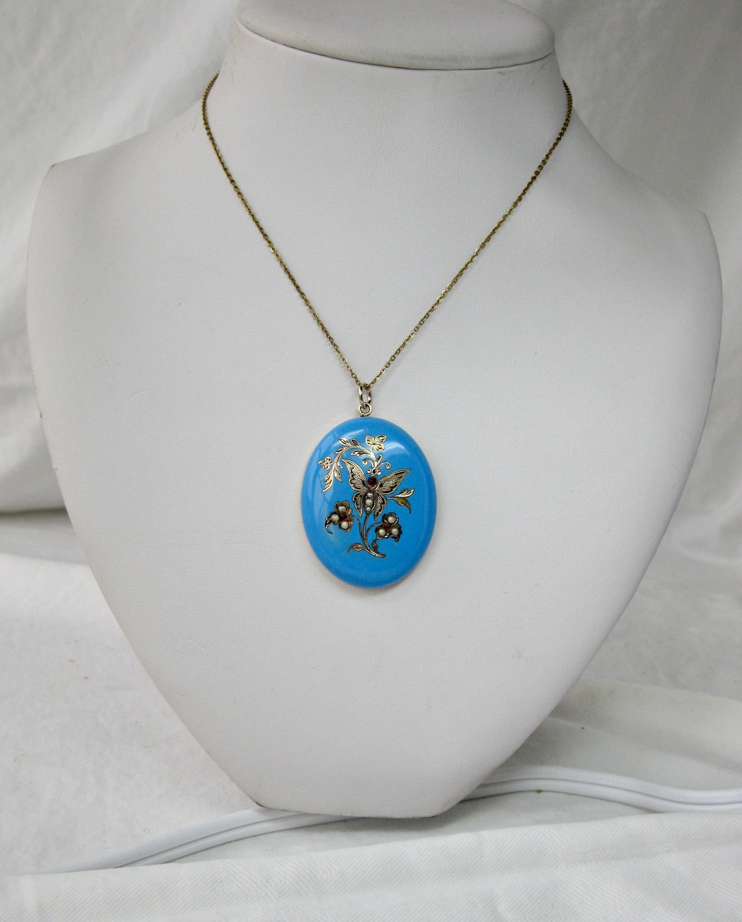 This is a rare and wonderful Victorian locket pendant with a Butterfly and Flowers set with Ruby and Pearl in 14 Karat Gold with Robin's Egg Blue Enamel.  The Butterfly Locket dates to the Victorian period when insect inspired jewelry was sweeping