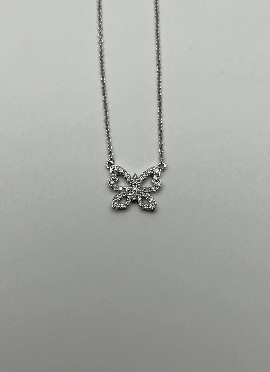 Este elegante collar colgante presenta un delicado diseño de mariposa adornado con brillantes diamantes blancos. La mariposa calada está meticulosamente engastada con diamantes que suman 0,6 quilates, creando un brillo cautivador. Realizado en oro